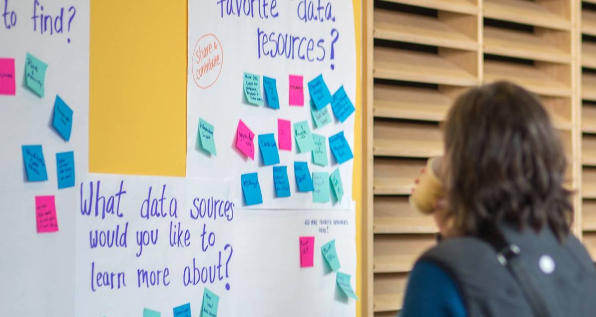 A person looks at posters on a wall about data resources