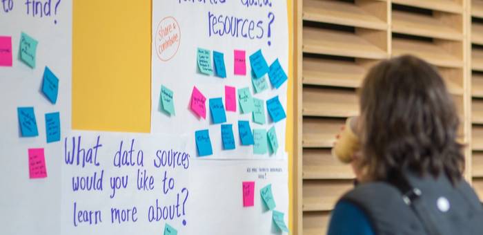 A person looks at posters on a wall about data resources