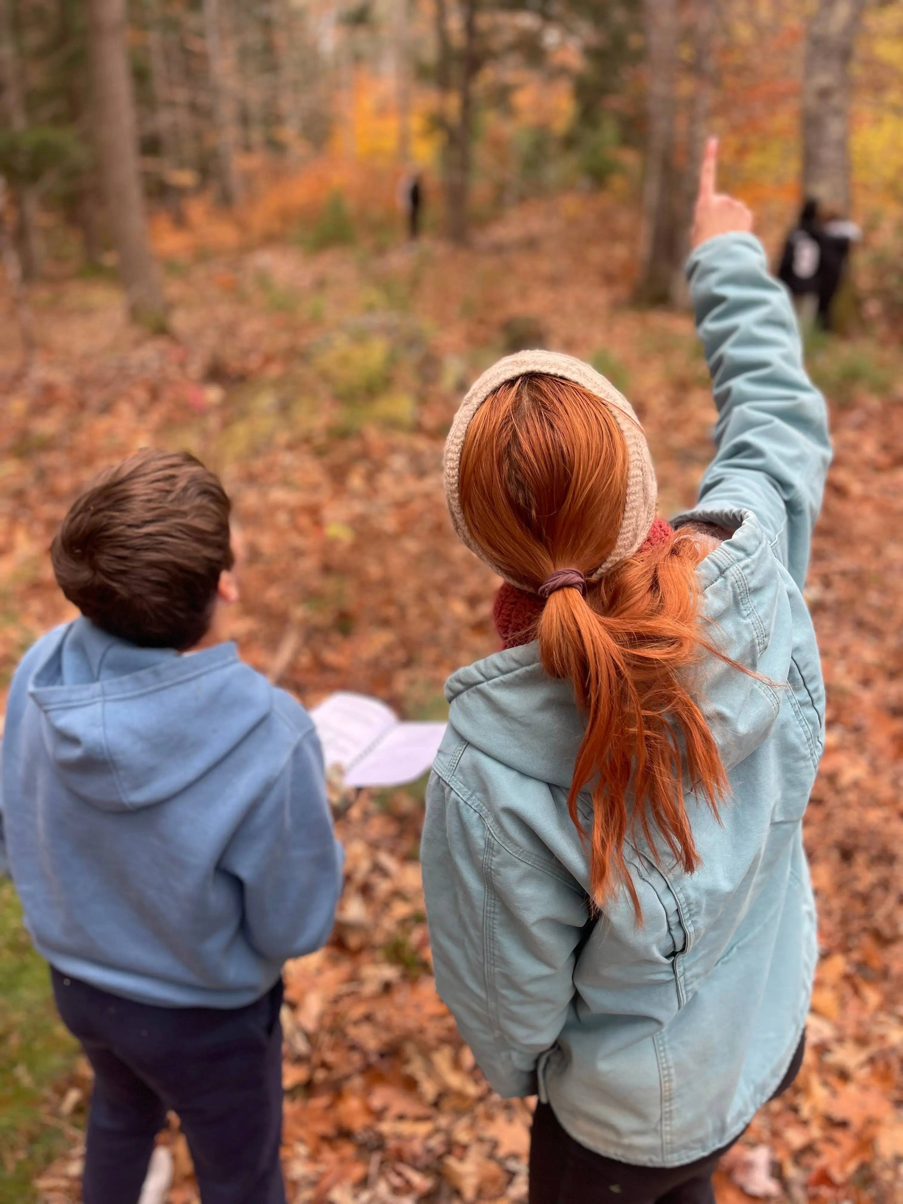 Two young people observe wildlife in an outdoor setting