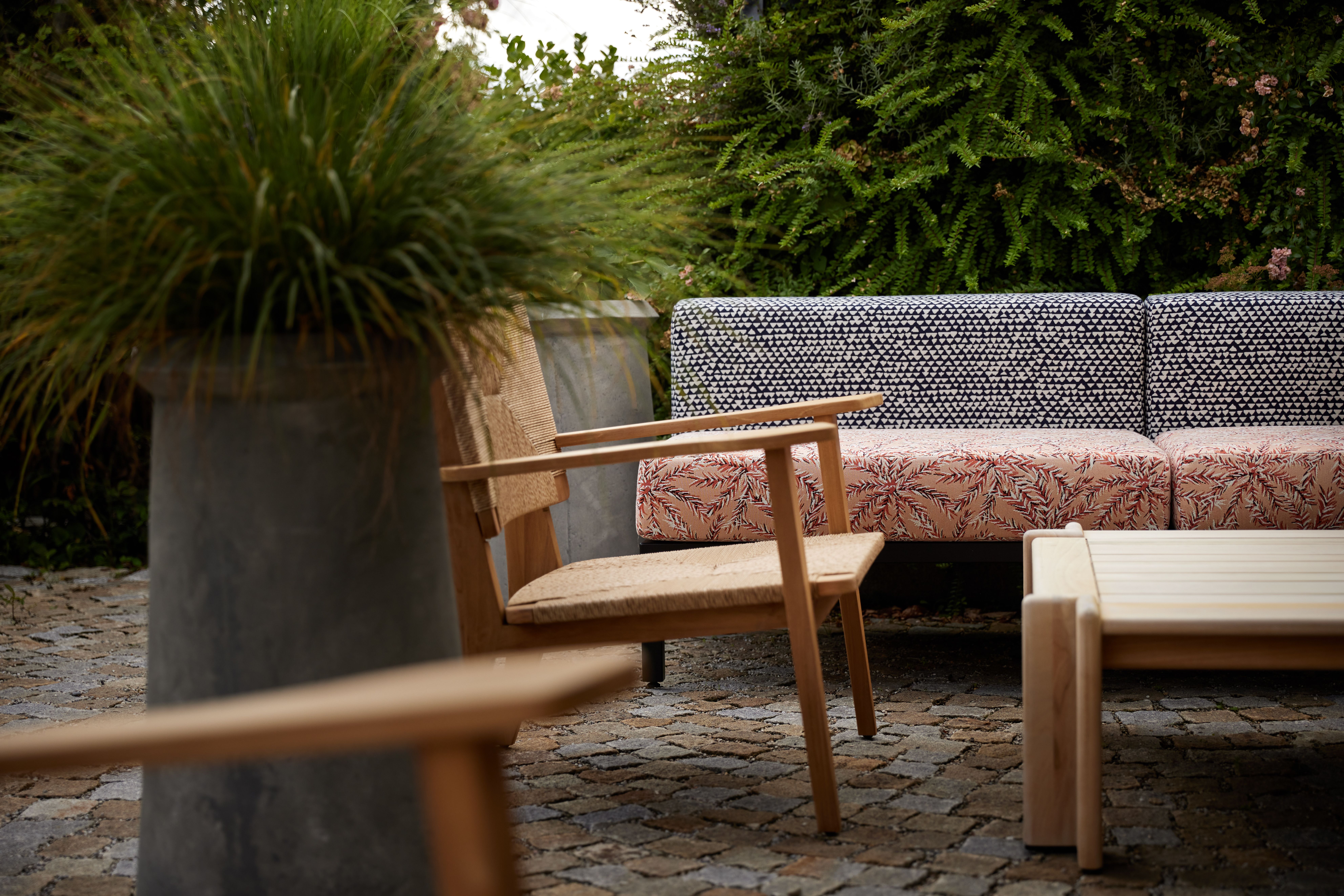 Outdoor-Lounge mit texturierten Performance-Stoffen und skulpturaler Gartenkulisse, gestaltet von Stephanie Thatenhorst für das Turbinenhaus Kolbermoor – Brasserie.