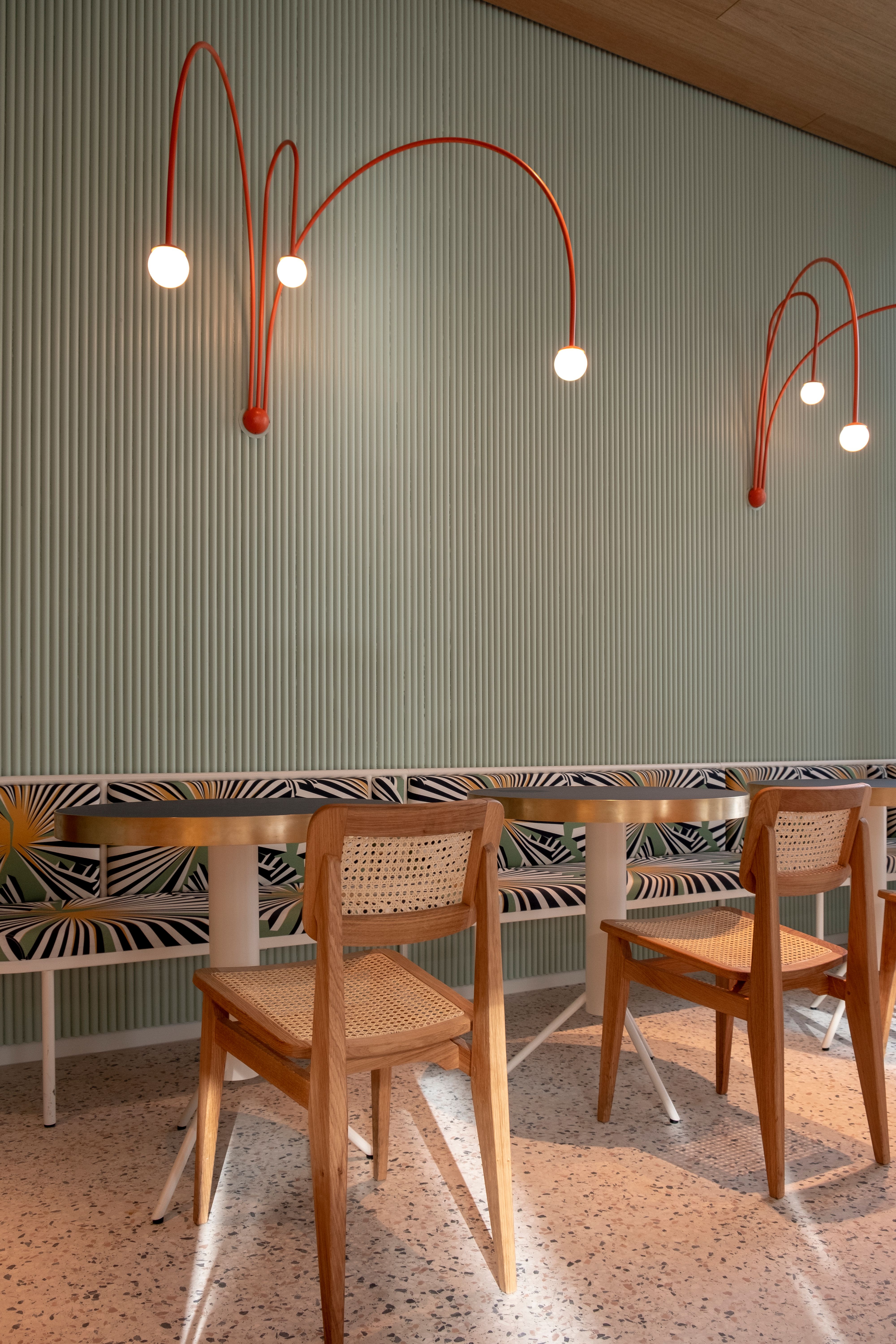 Im Lilli P Restaurant schafft das von Stephanie Thatenhorst gestaltete Interieur mit grafischen Polsterstoffen, Terrazzo-Boden und markanten Wandlampen eine moderne, verspielte Atmosphäre.