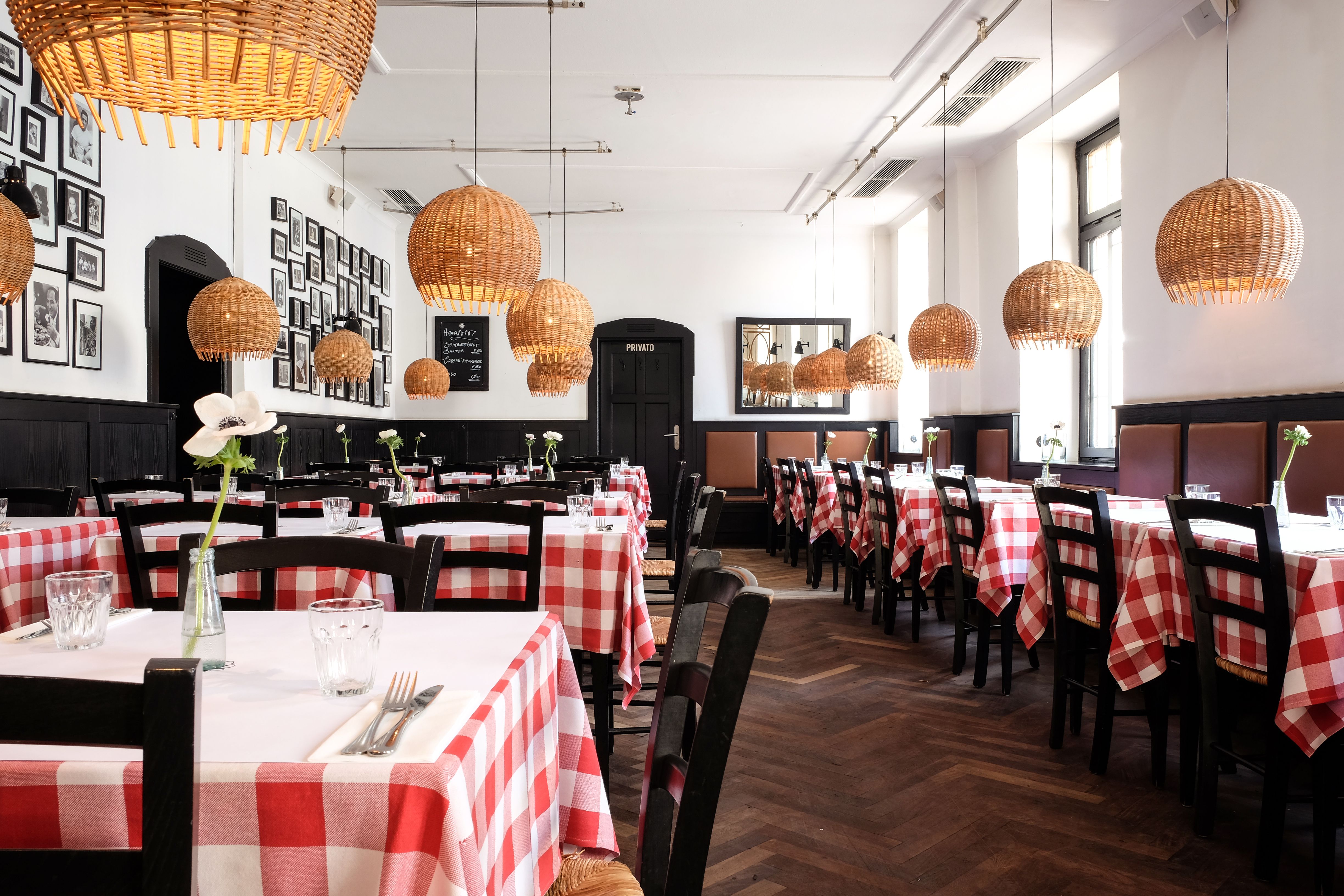 Der großzügige Gastraum mit rot-weiß karierten Tischdecken greift klassische Trattoria-Typologien zeitgemäß auf.