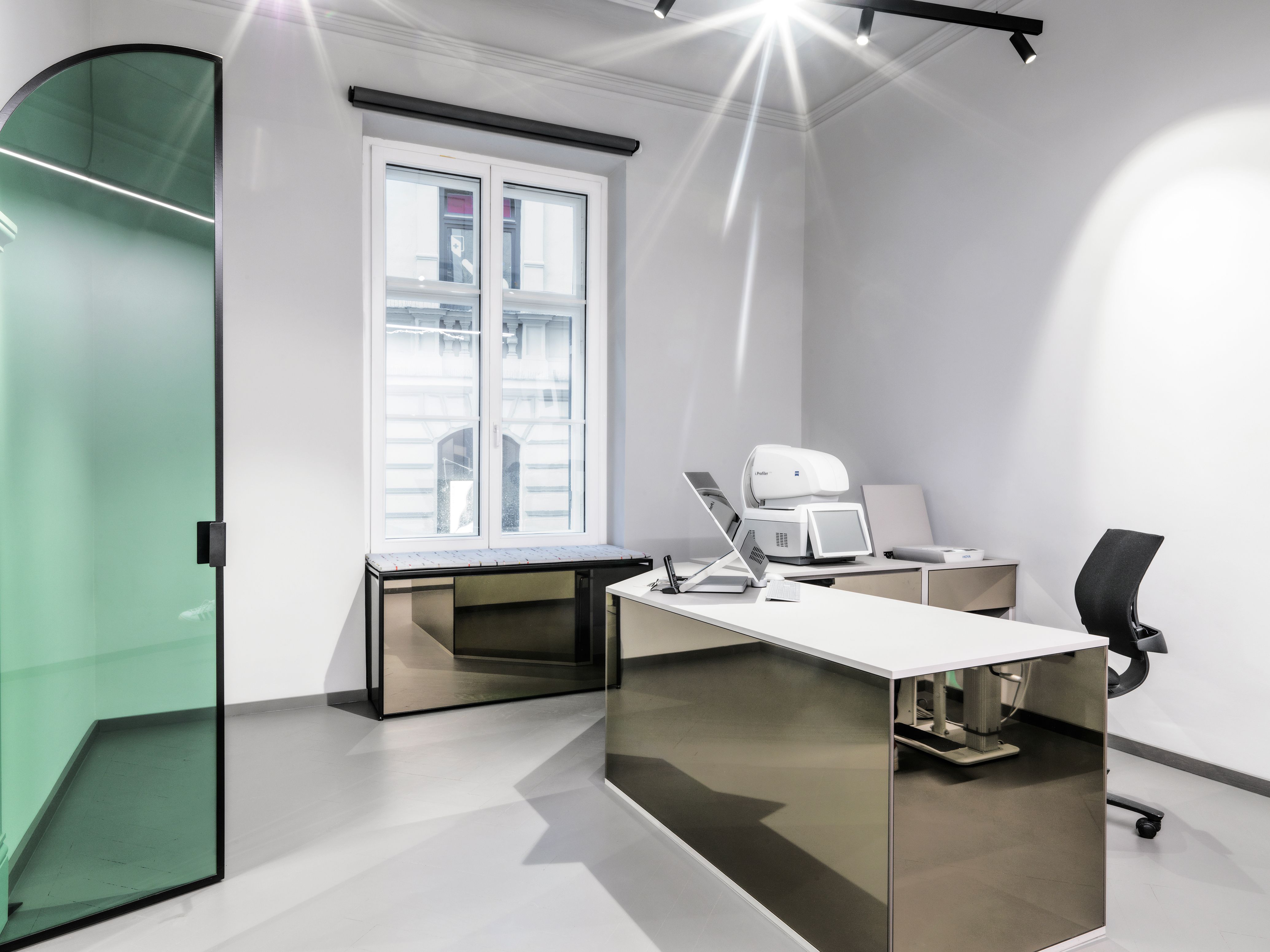 Dieser puristisch gestaltete Untersuchungsraum im Mykita Shop München wurde von Stephanie Thatenhorst mit spiegelnden Flächen und klaren Linien entworfen.