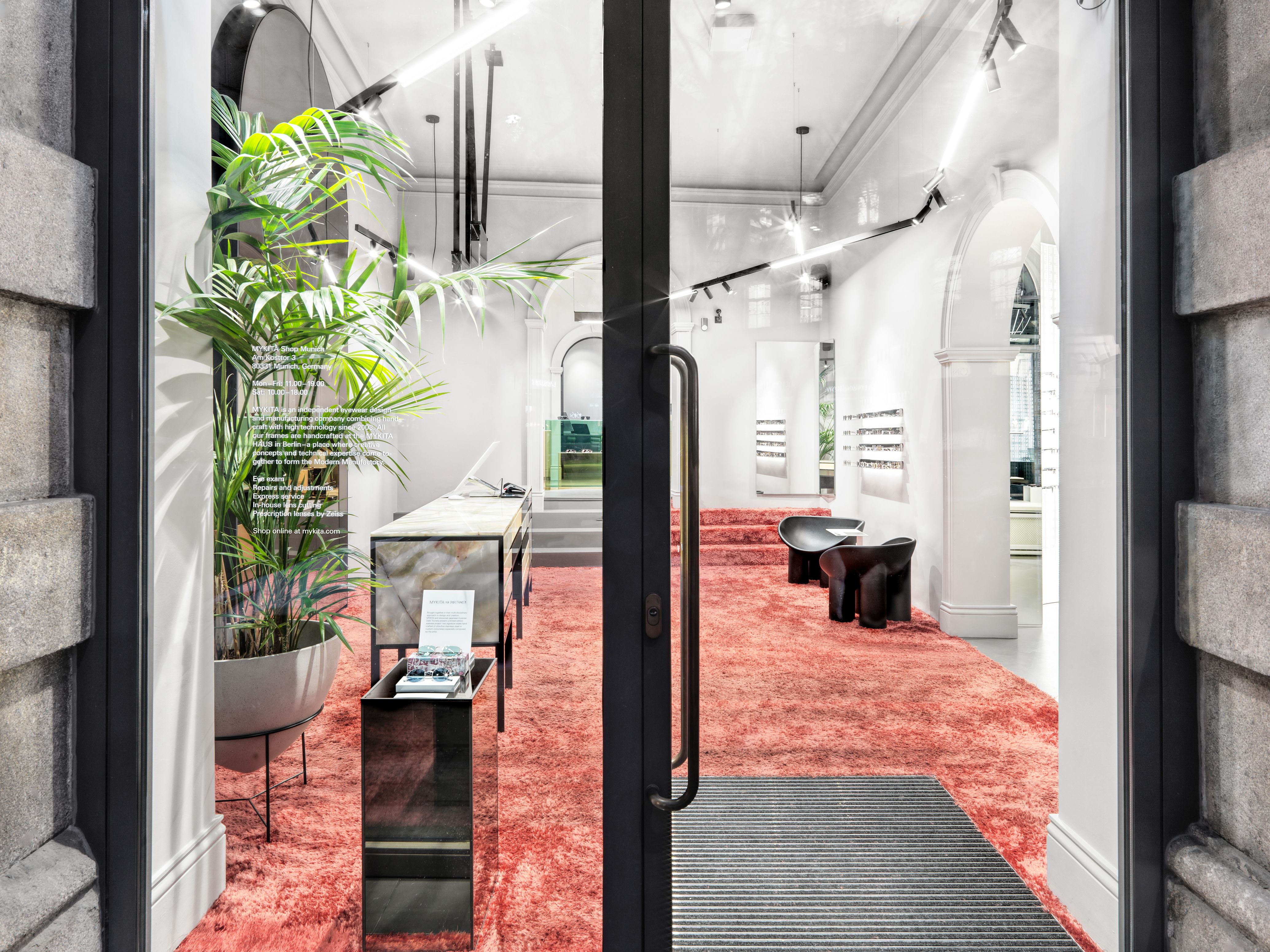 Die Eingangsperspektive des Mykita Shops München präsentiert das von Stephanie Thatenhorst gestaltete Interiorkonzept mit markantem rosa Teppich und eleganter Formensprache.