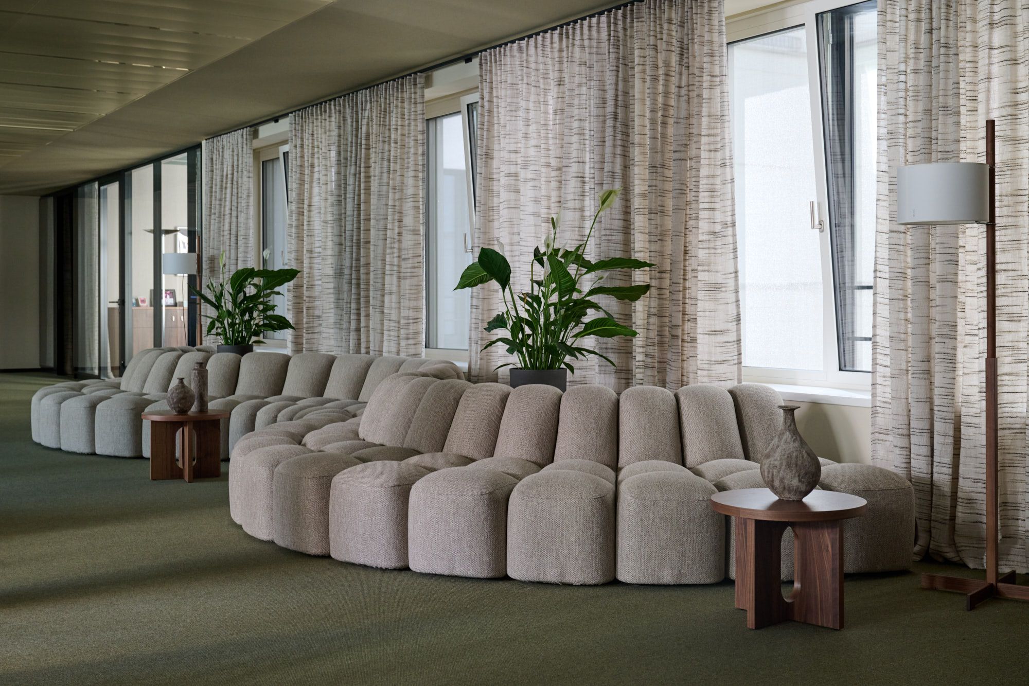 Im Büro Hass Dross Theiss setzt Stephanie Thatenhorst auf skulpturale Polsterlandschaften, natürliche Texturen und sanfte Farbnuancen, die eine ruhige und zugleich repräsentative Loungeatmosphäre formen.