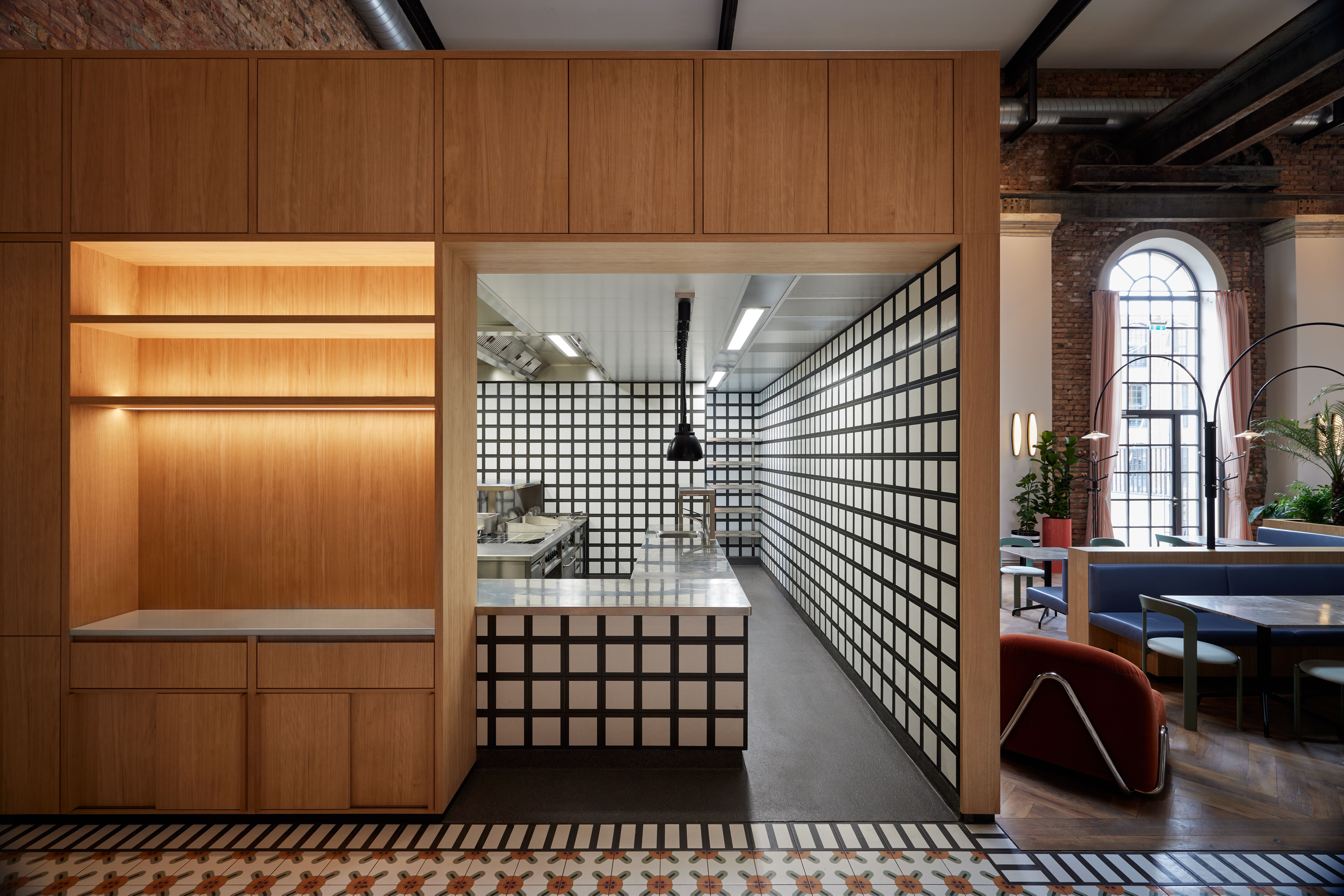 Die offene Küchenarchitektur mit strengem Kachelraster in der Brasserie des Turbinenhauses Kolbermoor wurde von Stephanie Thatenhorst als transparente Gourmet-Werkstatt konzipiert.