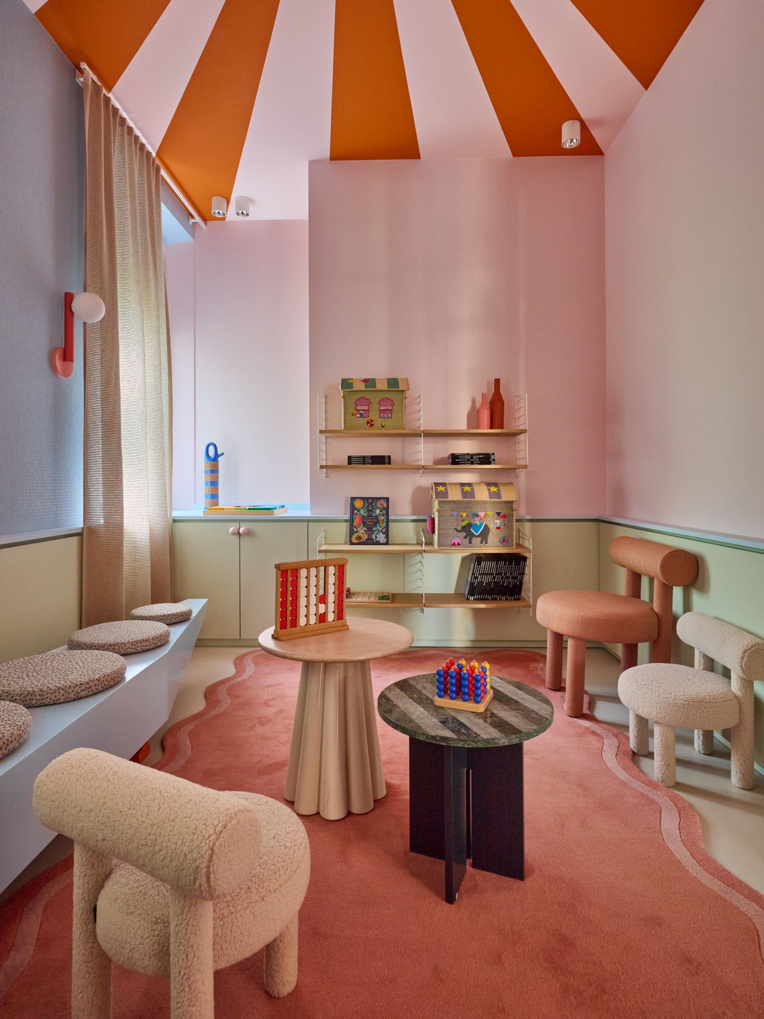 Verspieltes, farbenfrohes Kinderzimmer mit maßgefertigten Designmöbeln, weichem Teppich in organischer Form und kreativem Stauraum – eine stilvolle Wohlfühloase für modernes Familienwohnen und inspirierende Spielmomente.