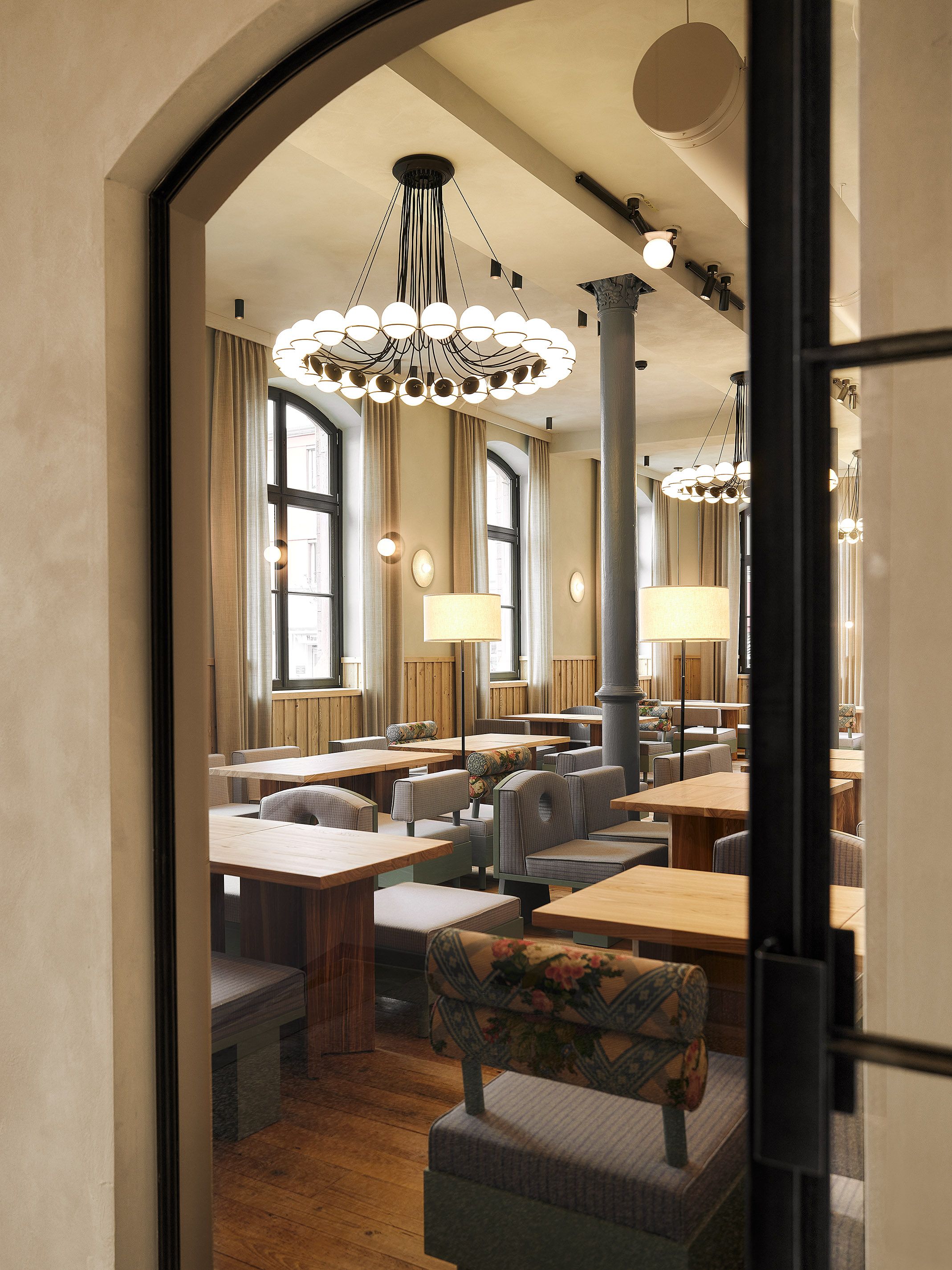 Großzügige Gasträume mit historischen Architekturdetails und modernen Leuchten verbinden bayerische Tradition mit zeitgemäßem Design.