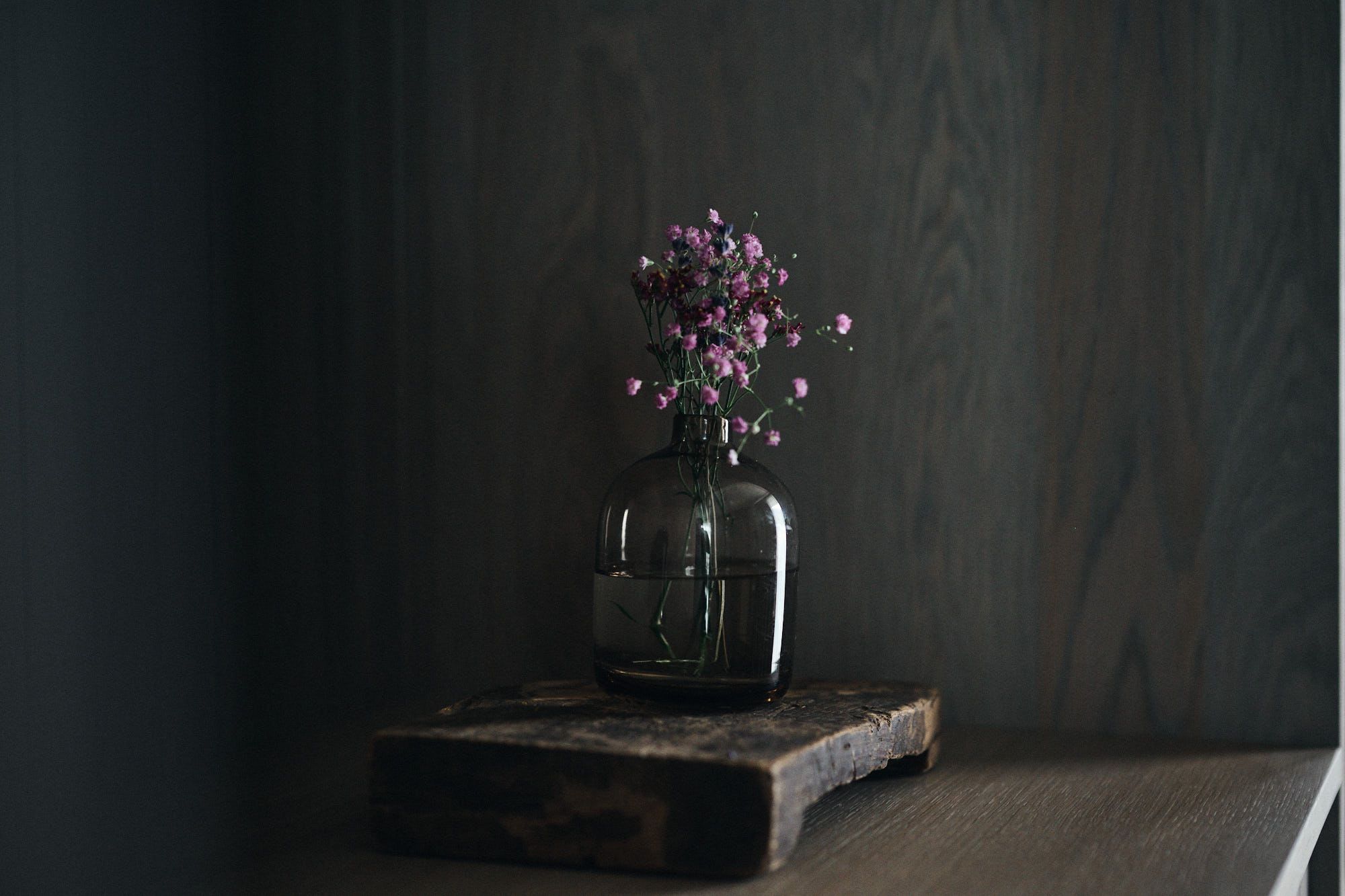 Die minimalistische Blumenkomposition in dunklem Glas zeigt das feine Stilgefühl von Stephanie Thatenhorst für natürliche Ästhetik im Ullrhaus.