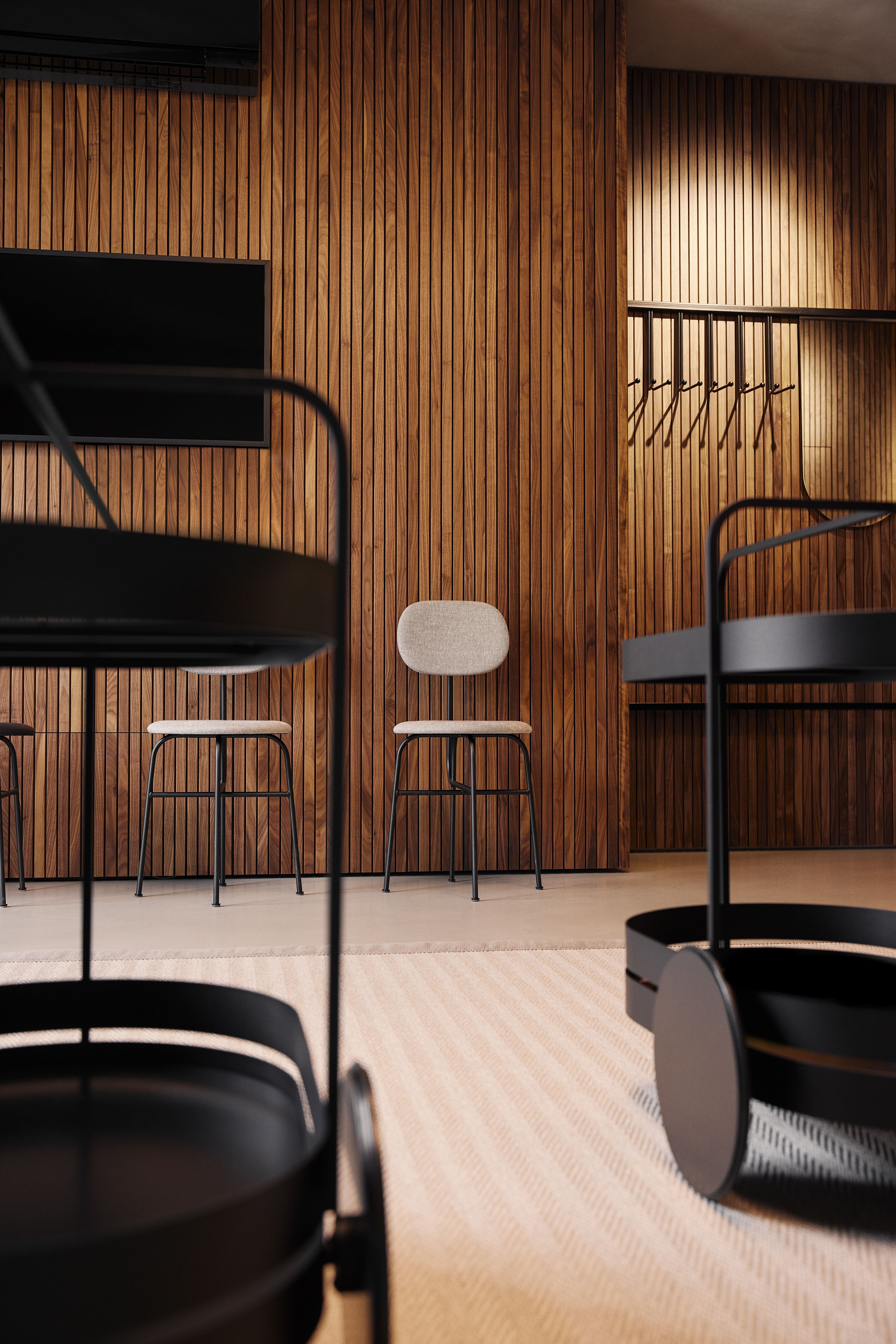 Der Wartebereich mit vertikaler Holzverkleidung und reduzierter Möblierung unterstreicht das hochwertige Interior-Design der Zahnarztpraxis Stephanie Thatenhorst in Kempten.