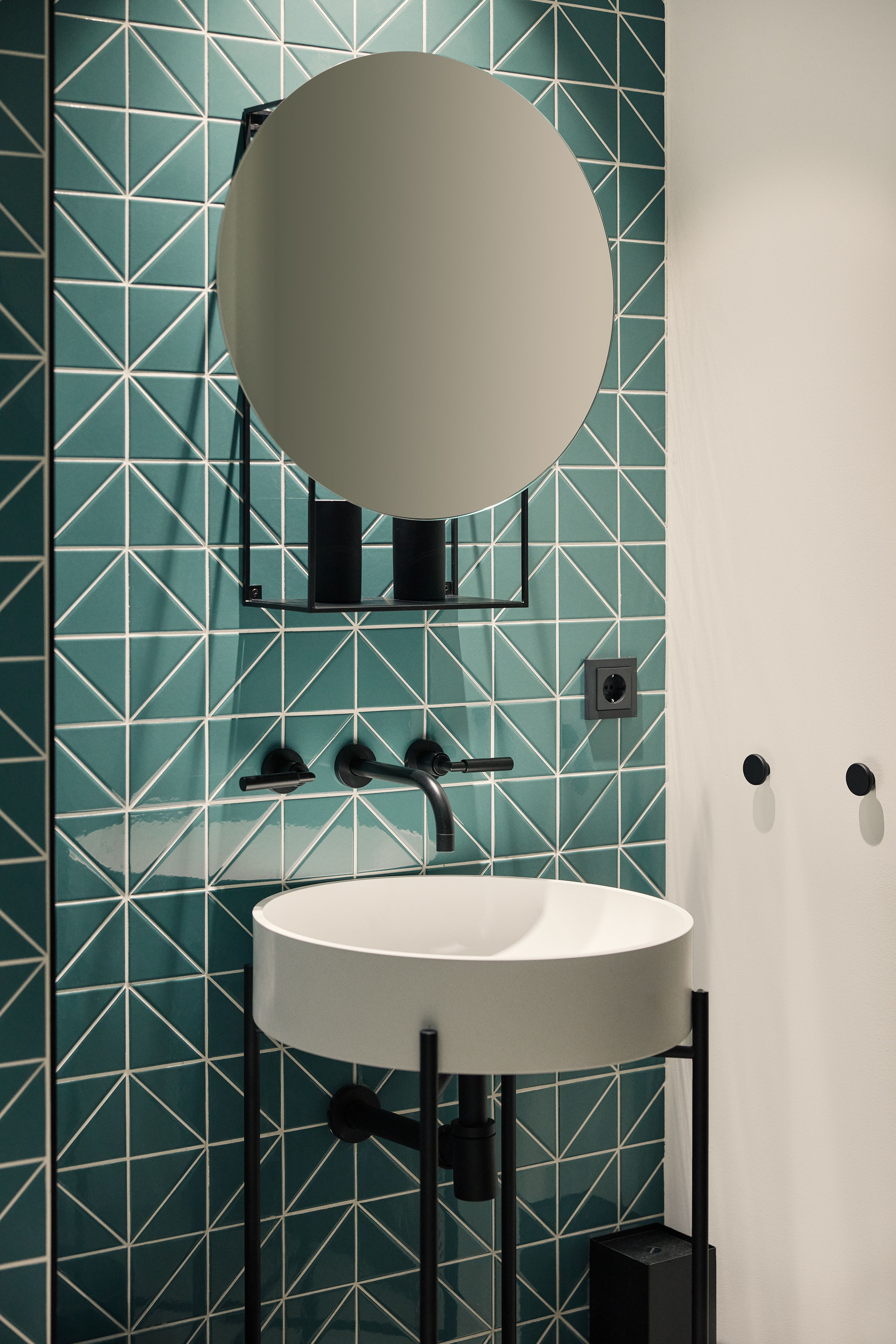 Der Sanitärbereich mit geometrischen Fliesen und freistehendem Waschtisch verbindet Hygiene, Design und Funktionalität in der Zahnarztpraxis Kempten.