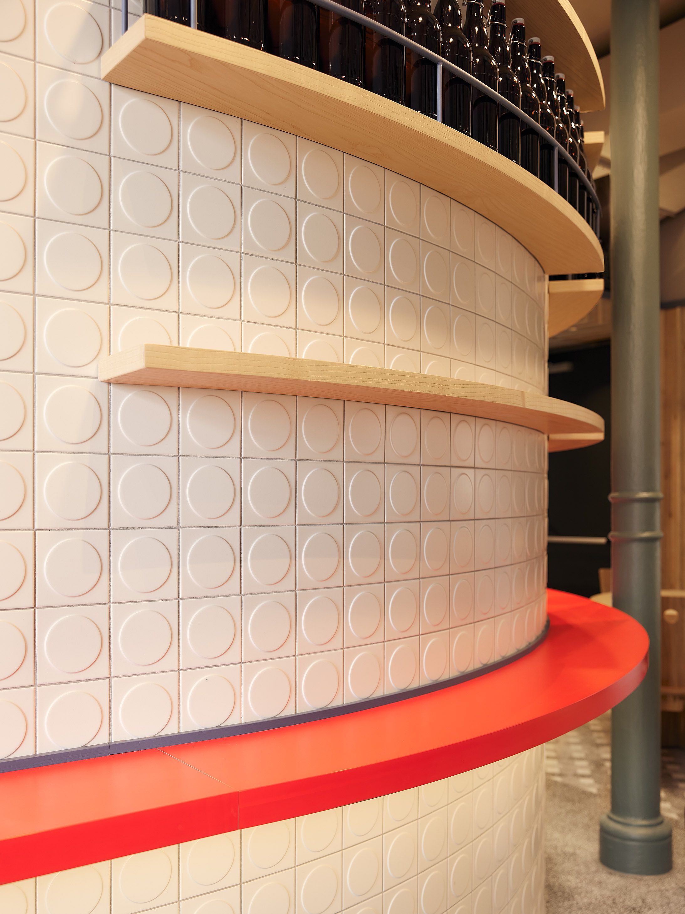 Die runde Bar mit klarer Geometrie und kontrastreichem Rot zeigt Stephanie Thatenhorsts mutige Formensprache im modernisierten Benediktiner Weissbräuhaus.