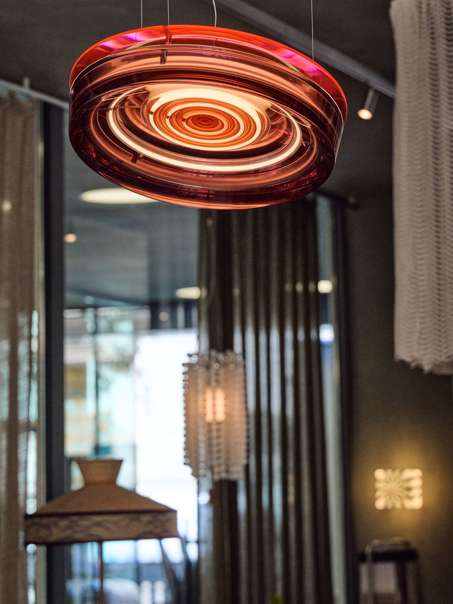 Moderne Designer-Pendelleuchte aus Glas, stilvoll inszeniert im exklusiven Showroom von Thatenhorst Interior.