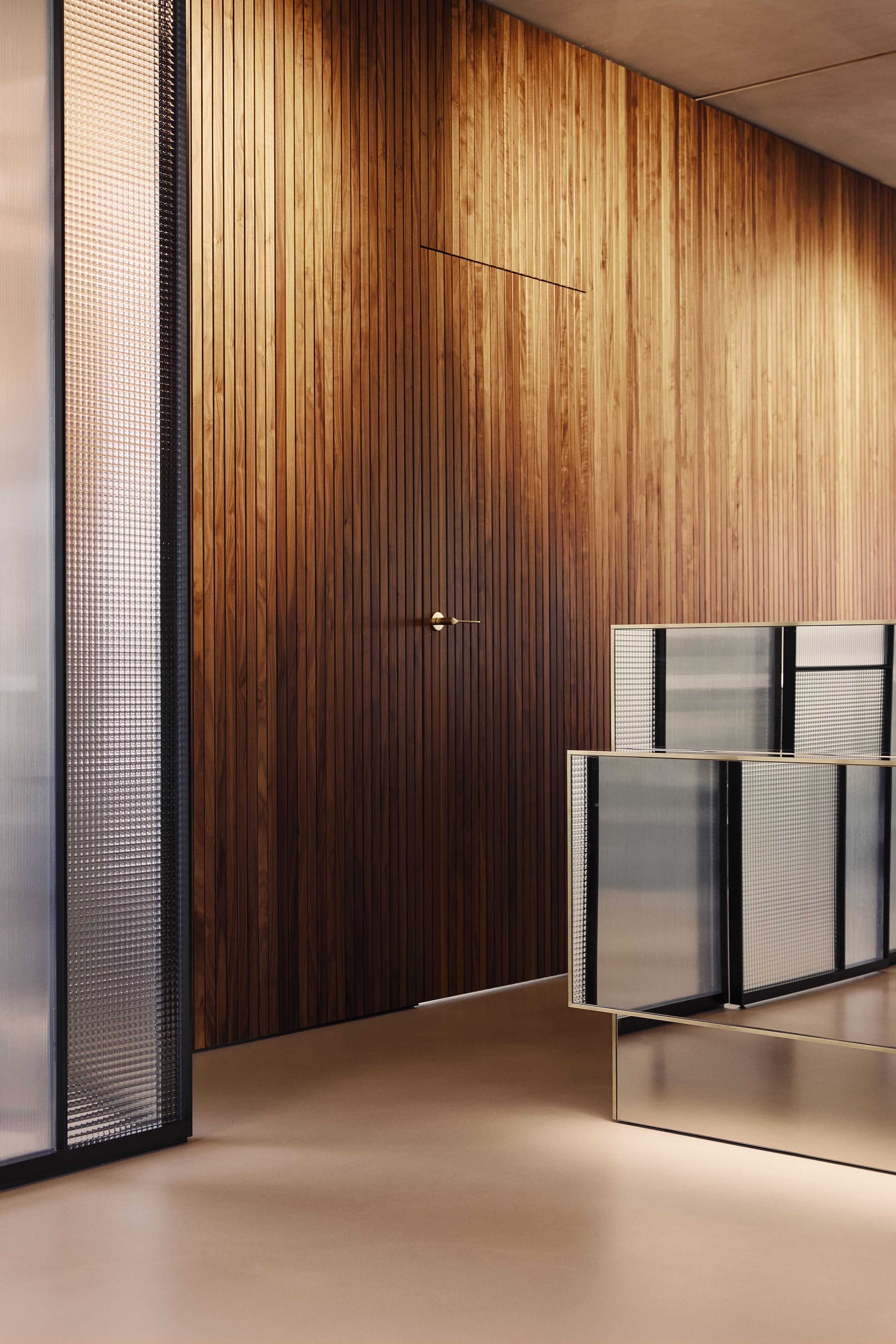 Vertikal strukturierte Holzverkleidungen prägen das Interior Design der Zahnarztpraxis Kempten und unterstreichen den hochwertigen, zeitlosen Charakter.