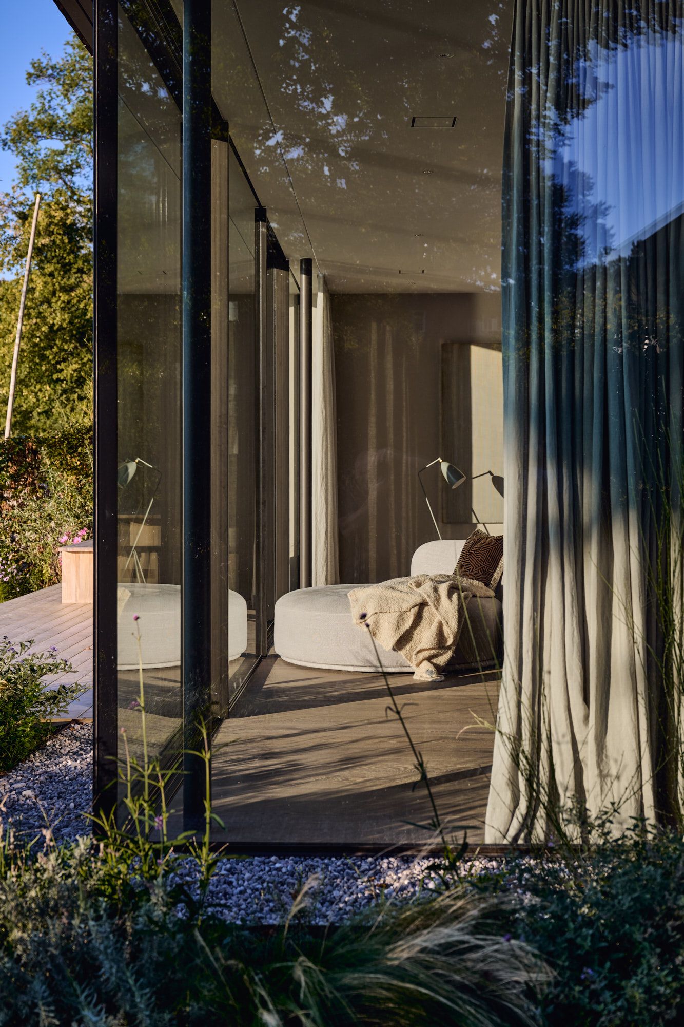 Dieses moderne Familienhaus verbindet offene Glasarchitektur, naturnahe Materialien und eine weiche, elegante Interiorsprache zu einem lichtdurchfluteten und zeitgemäßen Wohnkonzept.
