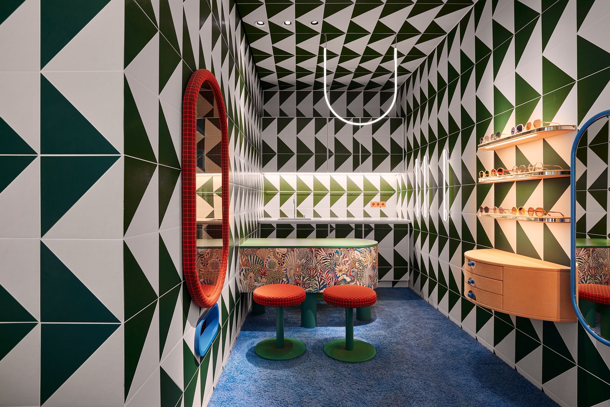 Der Beratungsbereich kombiniert expressive Muster, runde Sitzhocker und eine kreative Farbwelt zu einem einladenden Raumkonzept – designt von Stephanie Thatenhorst für Rookies Eyewear for Kids.