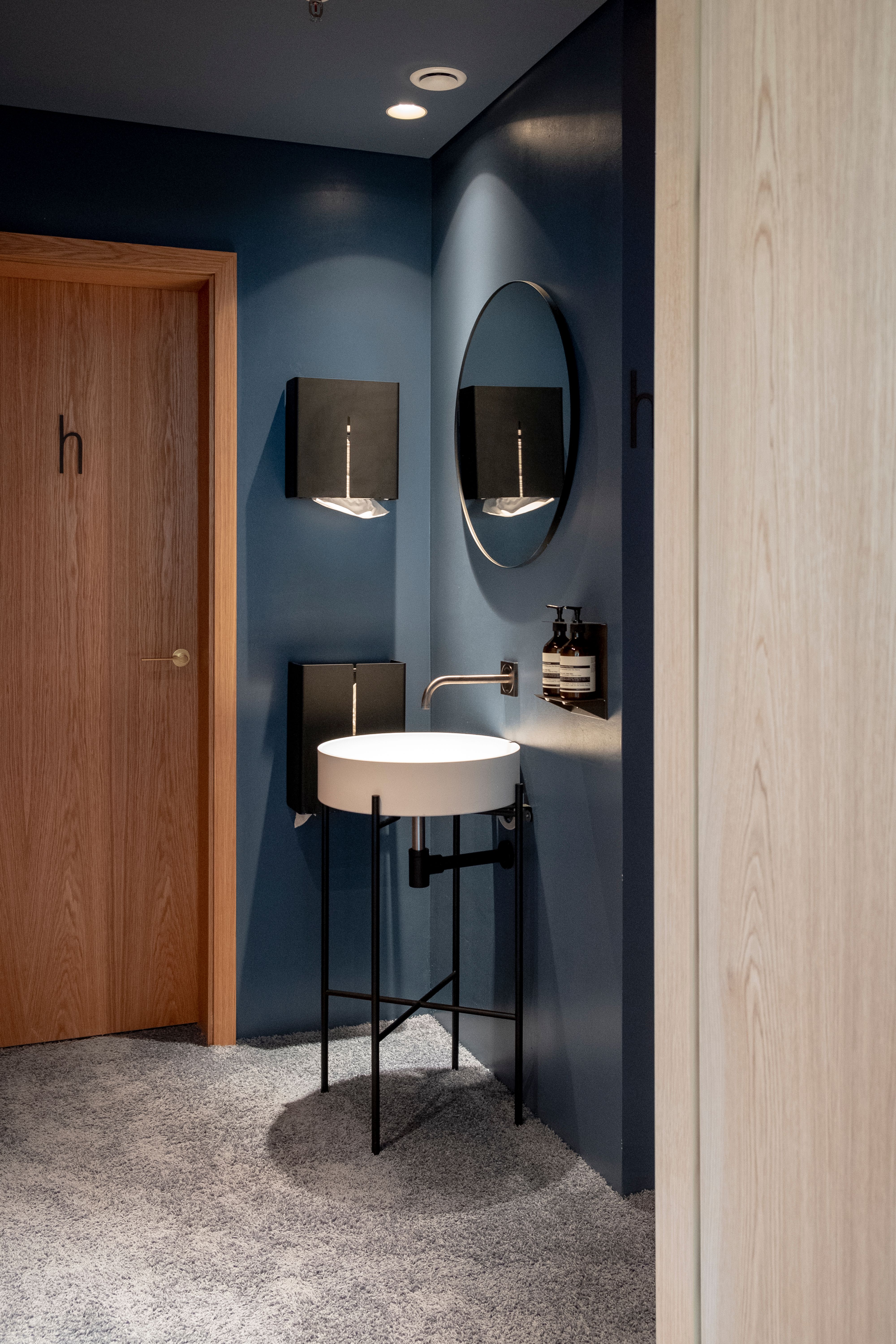 Im Sanitärbereich des Lilli P kombiniert Stephanie Thatenhorst dunkle Wandtöne, moderne Armaturen und minimalistisches Design zu einem ruhigen, eleganten Raumgefühl.