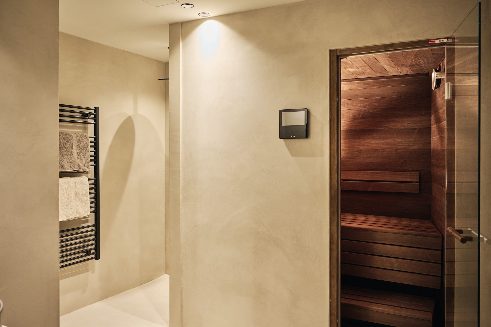 Das Ullrhaus-Wellnessbad mit Sauna zeigt Stephanie Thatenhorsts Fähigkeit, klare Architektur und warme Materialien zu einem ruhigen Rückzugsraum zu vereinen.