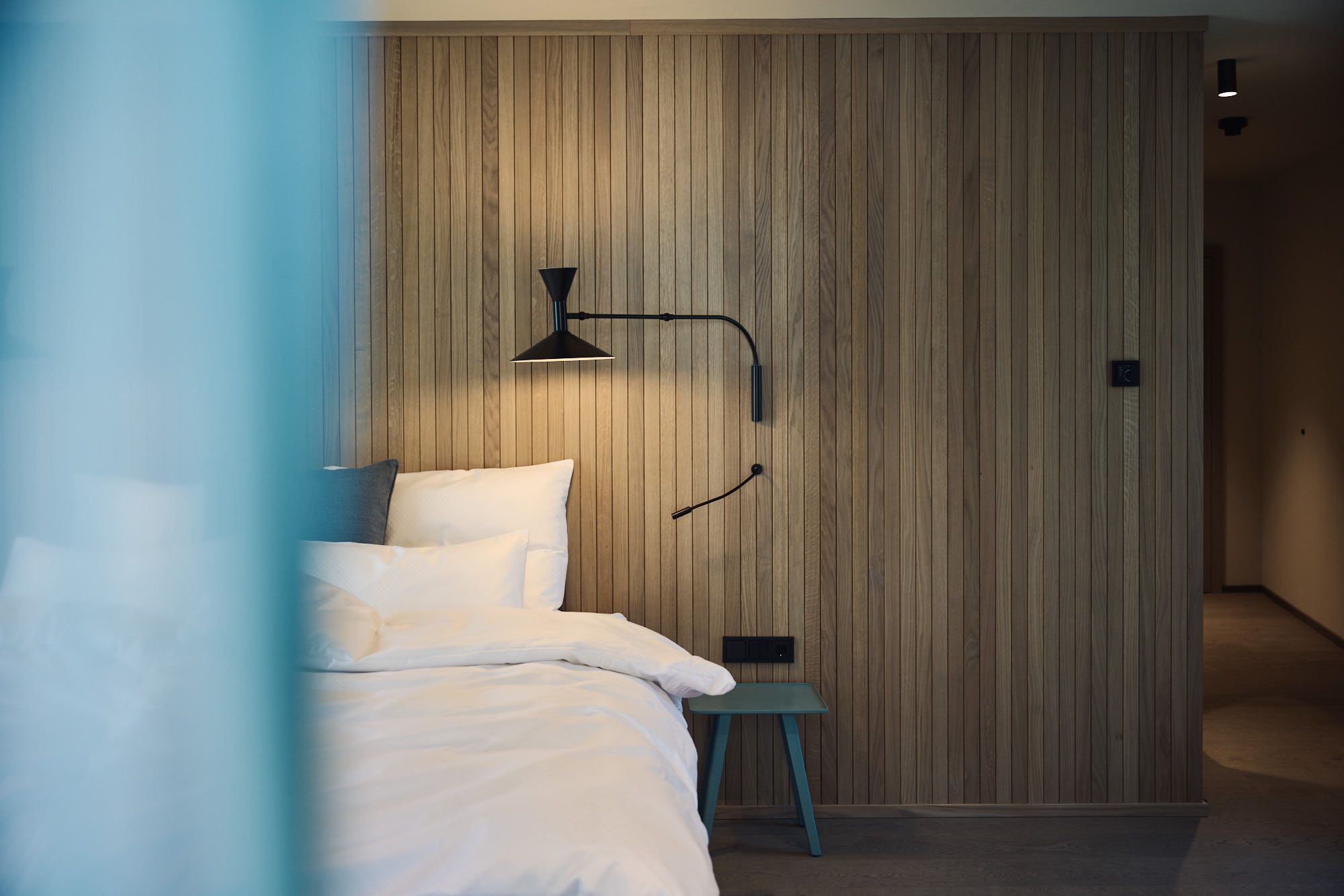 Die Aufnahme inszeniert das Ullrhaus-Schlafzimmer von Stephanie Thatenhorst, in dem warme Holzflächen und klare Linien eine harmonische Rückzugsatmosphäre schaffen.