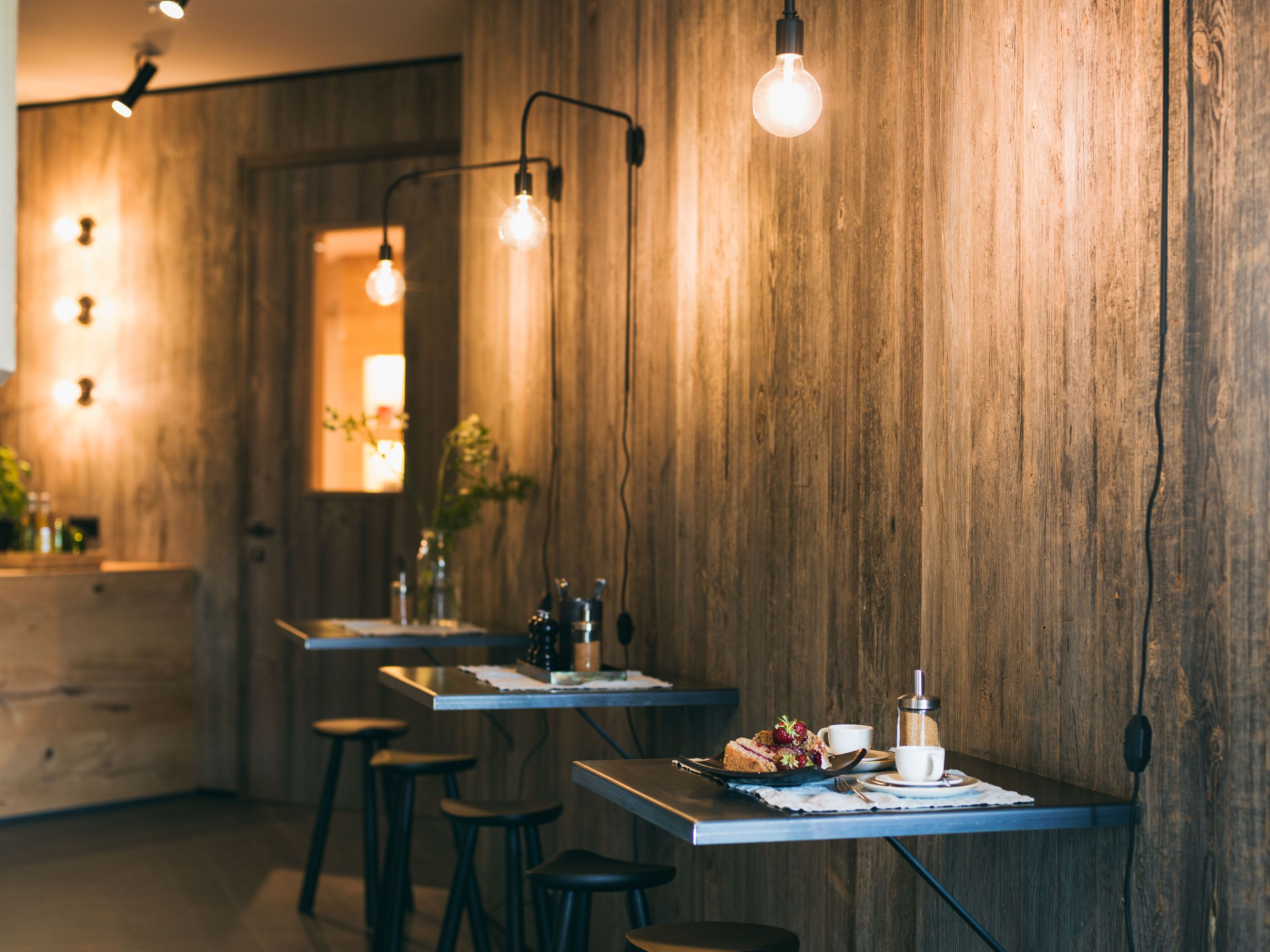 Der intime Café- und Barbereich im Schönherrhaus Hotel bietet mit warmem Licht und reduzierter Gestaltung einen ruhigen Ort zum Verweilen.