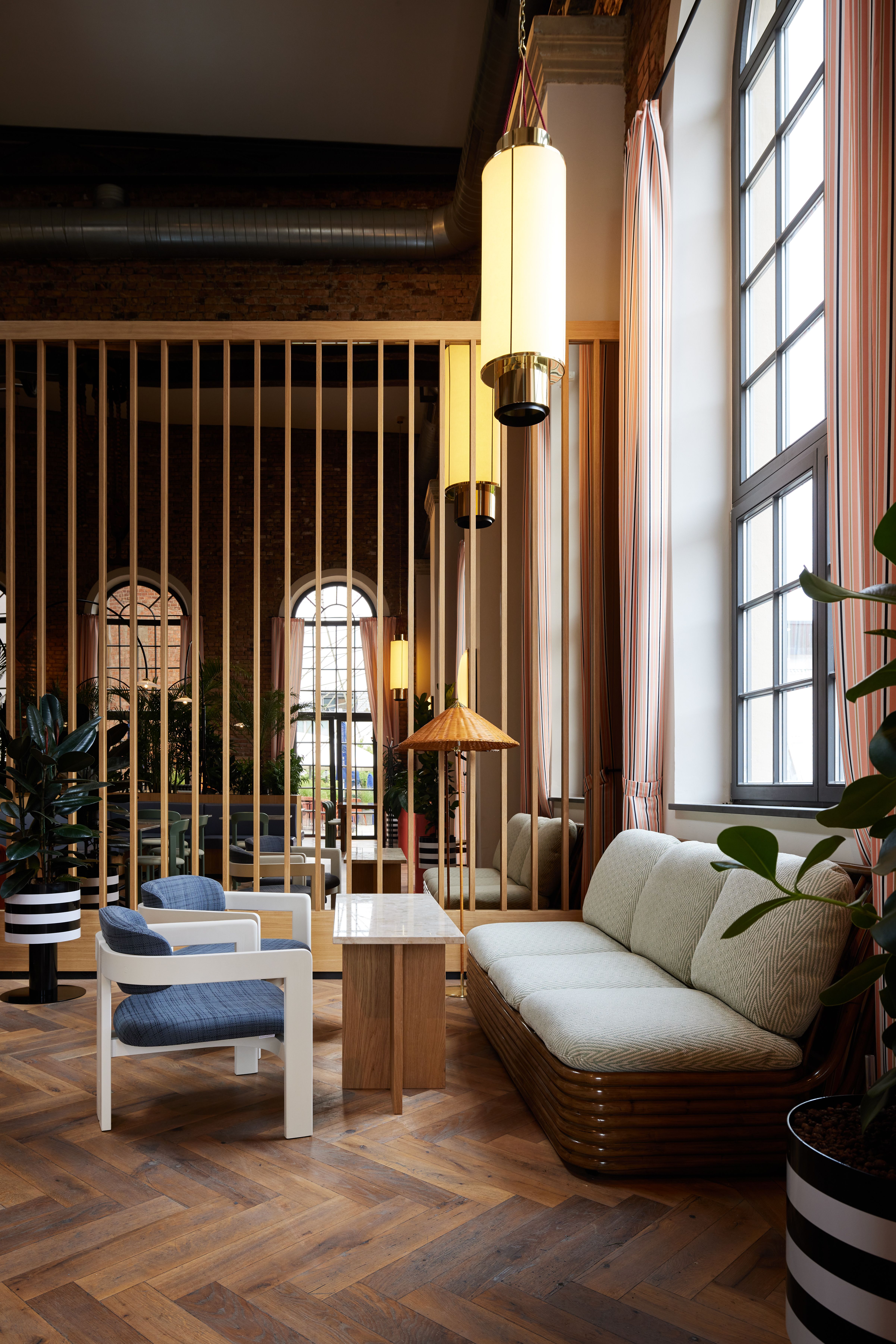 Dieses Bild zeigt die zentral inszenierte Bararchitektur der Brasserie im Turbinenhaus Kolbermoor, gestaltet von Stephanie Thatenhorst mit expressiver Rasterfassade, industrieller Ziegelstruktur und maßgefertigter Sitzlandschaft.