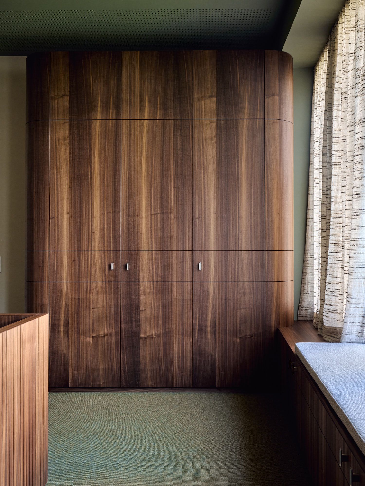 Mit fließenden Rundungen, durchgängigem Nussbaumfurnier und präziser Einbaumöblierung gestaltet Stephanie Thatenhorst im Büro Hass Dross Theiss eine ruhige, hochwertige Raumarchitektur.