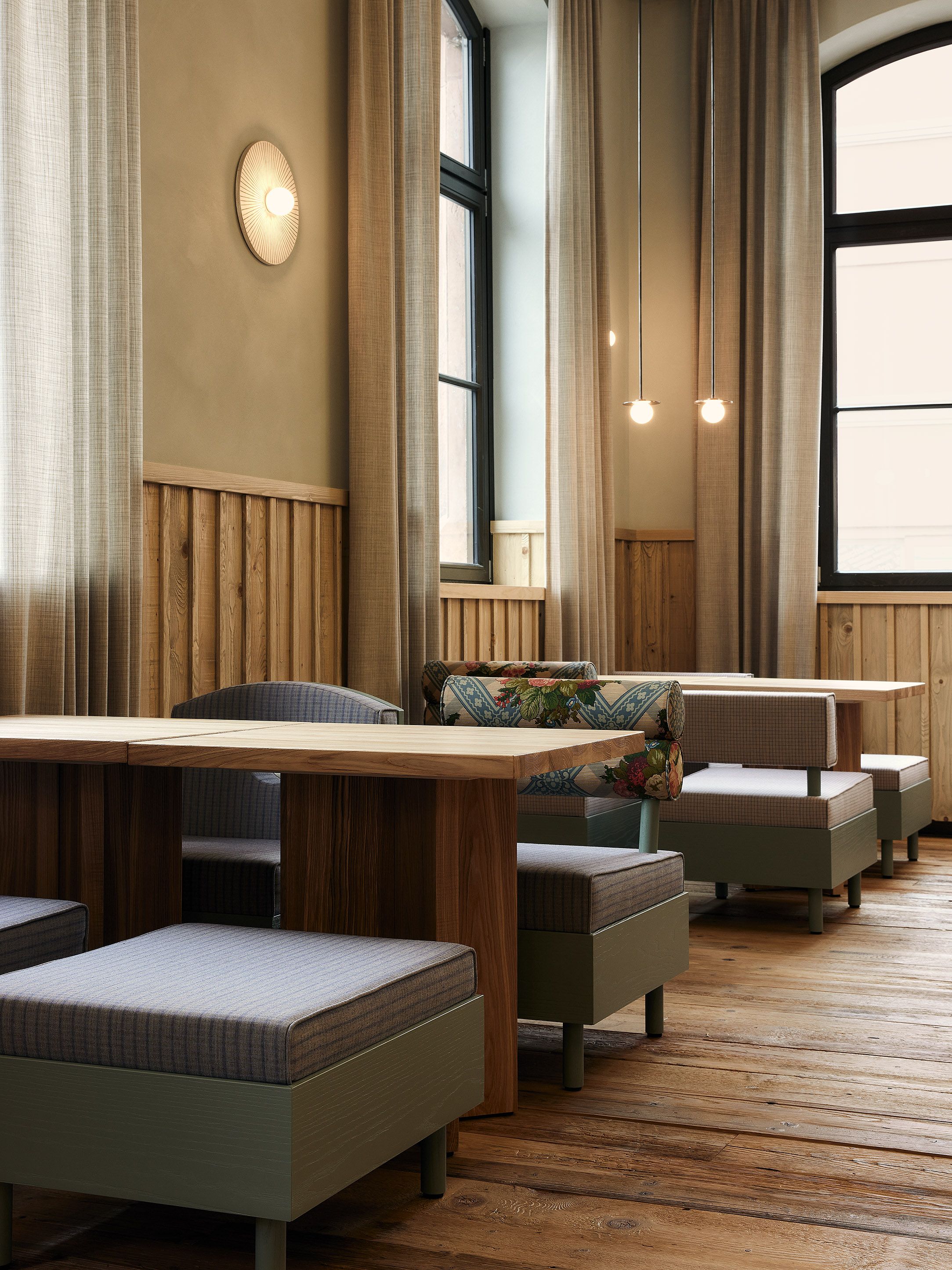 Warme Holzvertäfelungen, weiche Textilien und dezente Lichtstimmungen prägen das einladende Ambiente des Restaurants.