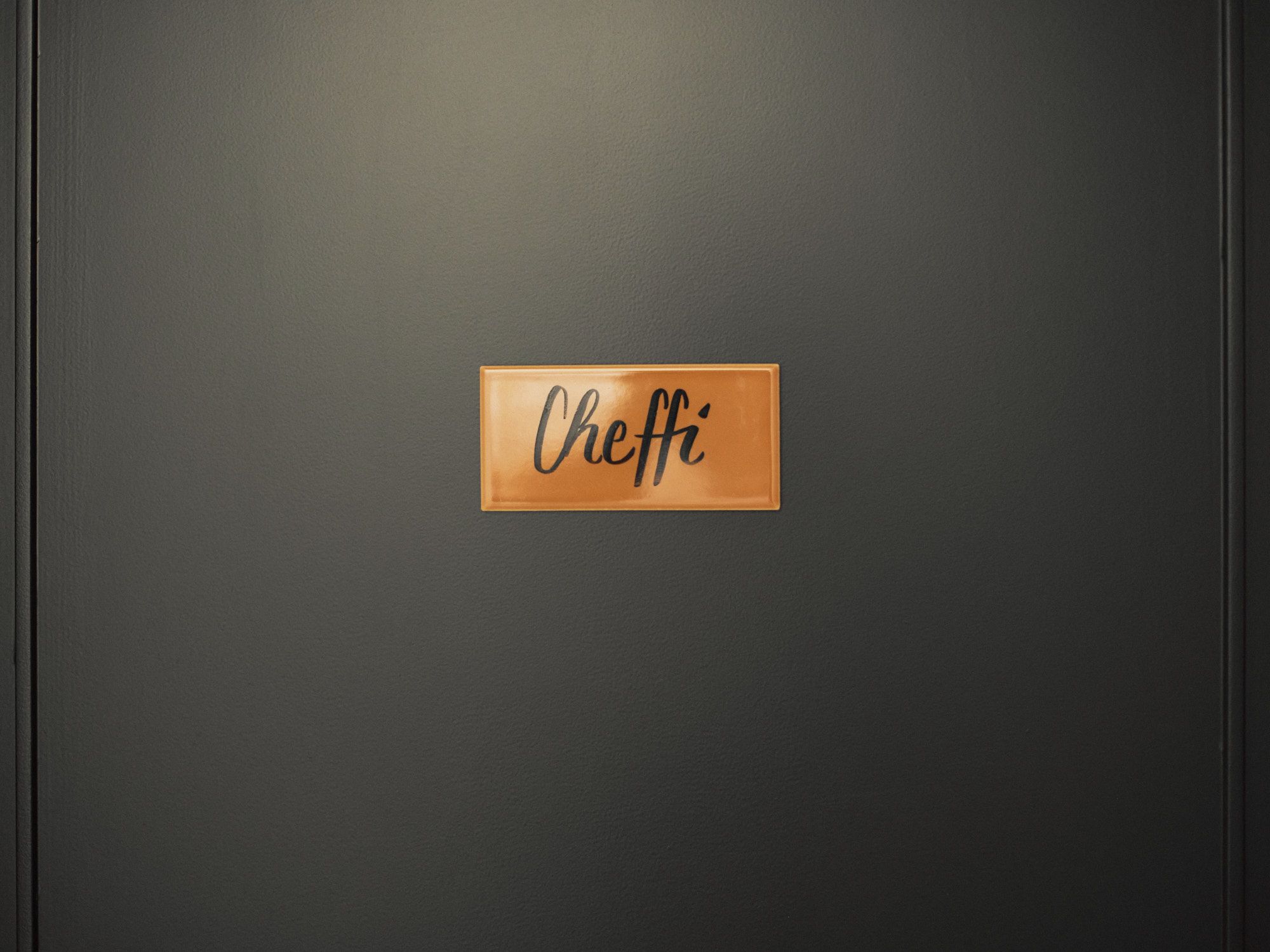 Individuelle Detailgestaltung zeigt sich in maßgefertigten Beschriftungen und präzise ausgeführten Oberflächen, die den ganzheitlichen Designanspruch des Studios widerspiegeln.