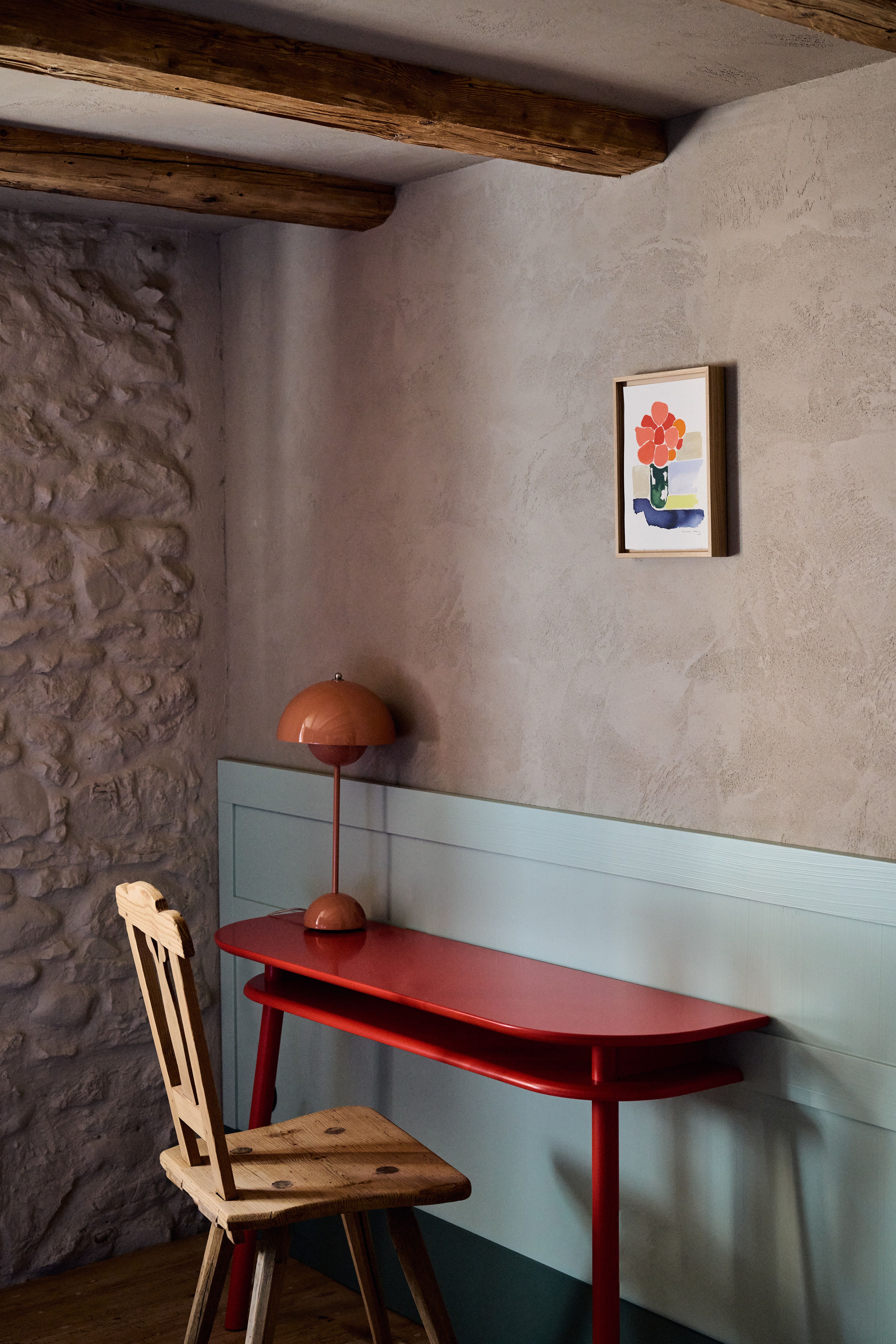 Designed by Stephanie Thatenhorst, vereint dieser bewusst reduzierte Arbeitsbereich rustikale Steintextur, sanft getönten Wandputz und einen farbbetonten Schreibplatz zu einer grafisch klaren, modernen Landhausinterpretation.