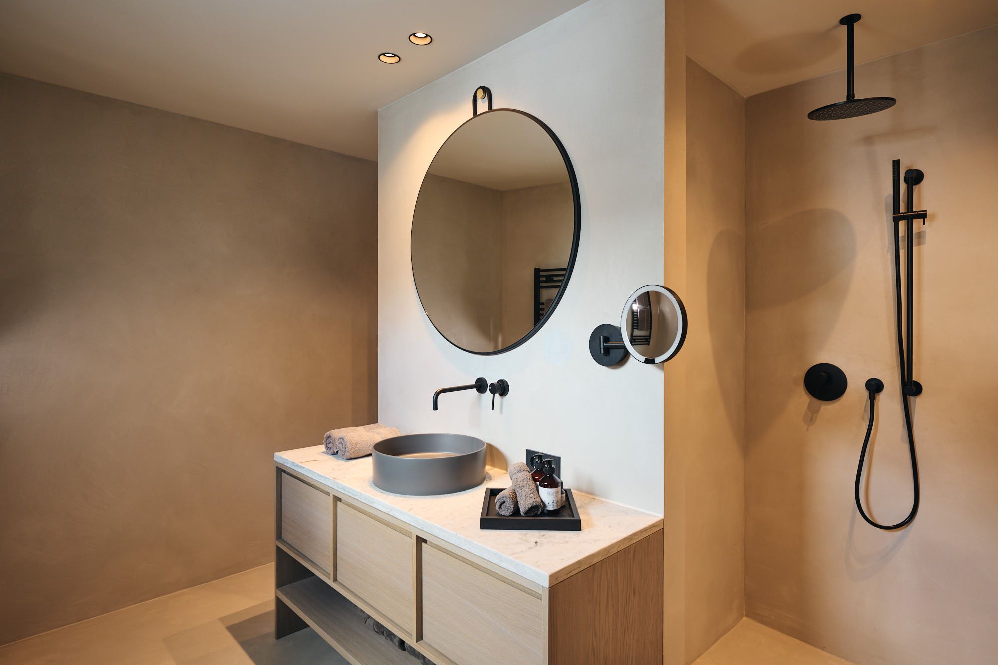 Das von Stephanie Thatenhorst designte Bad im Ullrhaus zeigt eine klare Formsprache mit runden Spiegeln, Naturtönen und puristischen Armaturen.