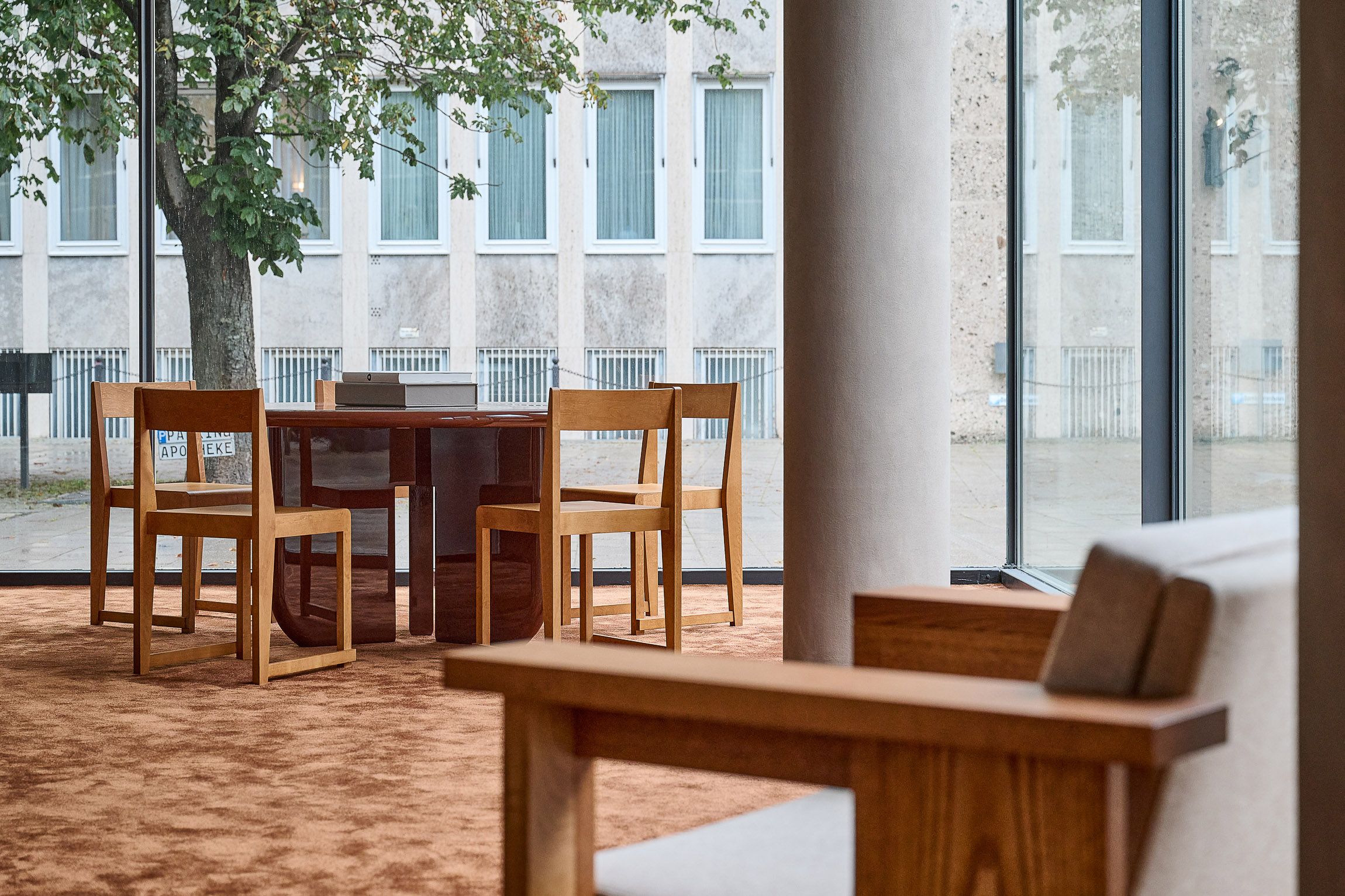 Meetingtisch im Sichtbeton-Raum mit Fensterfront, designt von Stephanie Thatenhorst, Studio Gerlinde Kusstatscher.