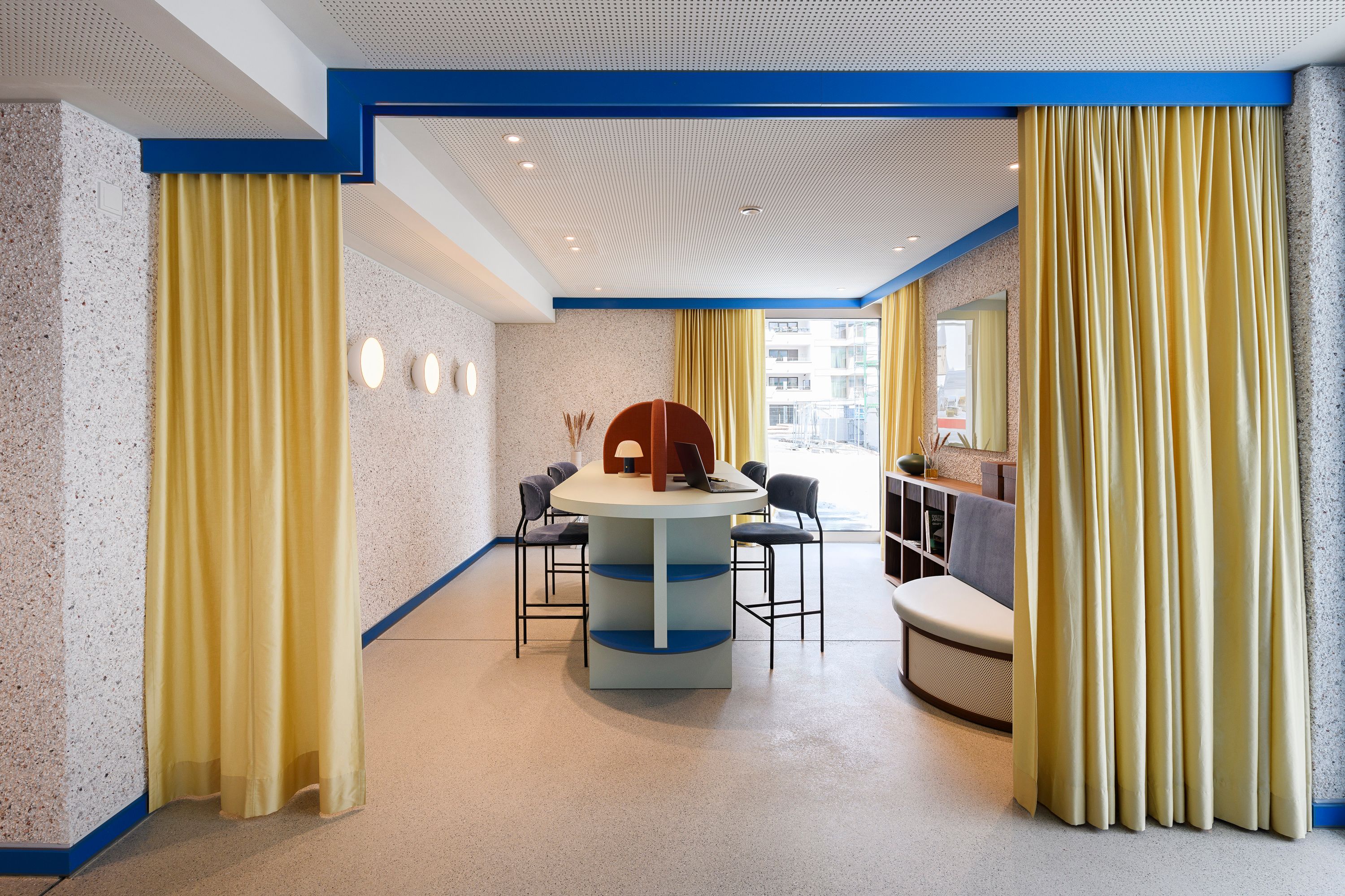 Der kommunikative Besprechungsbereich mit gelben Vorhängen und geometrischen Formen wurde von Stephanie Thatenhorst designt und verleiht der Kupa – Kitchen & Working Lounge modernen Charakter.