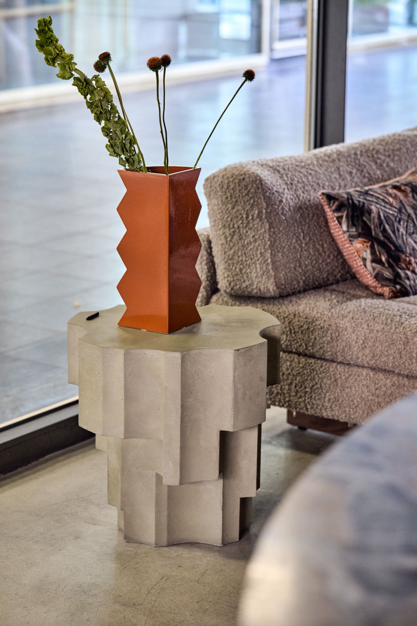 Detailaufnahme aus dem Showroom von Stephanie Thatenhorst mit skulpturalem Beistelltisch und Designvase in moderner Interior-Atmosphäre.