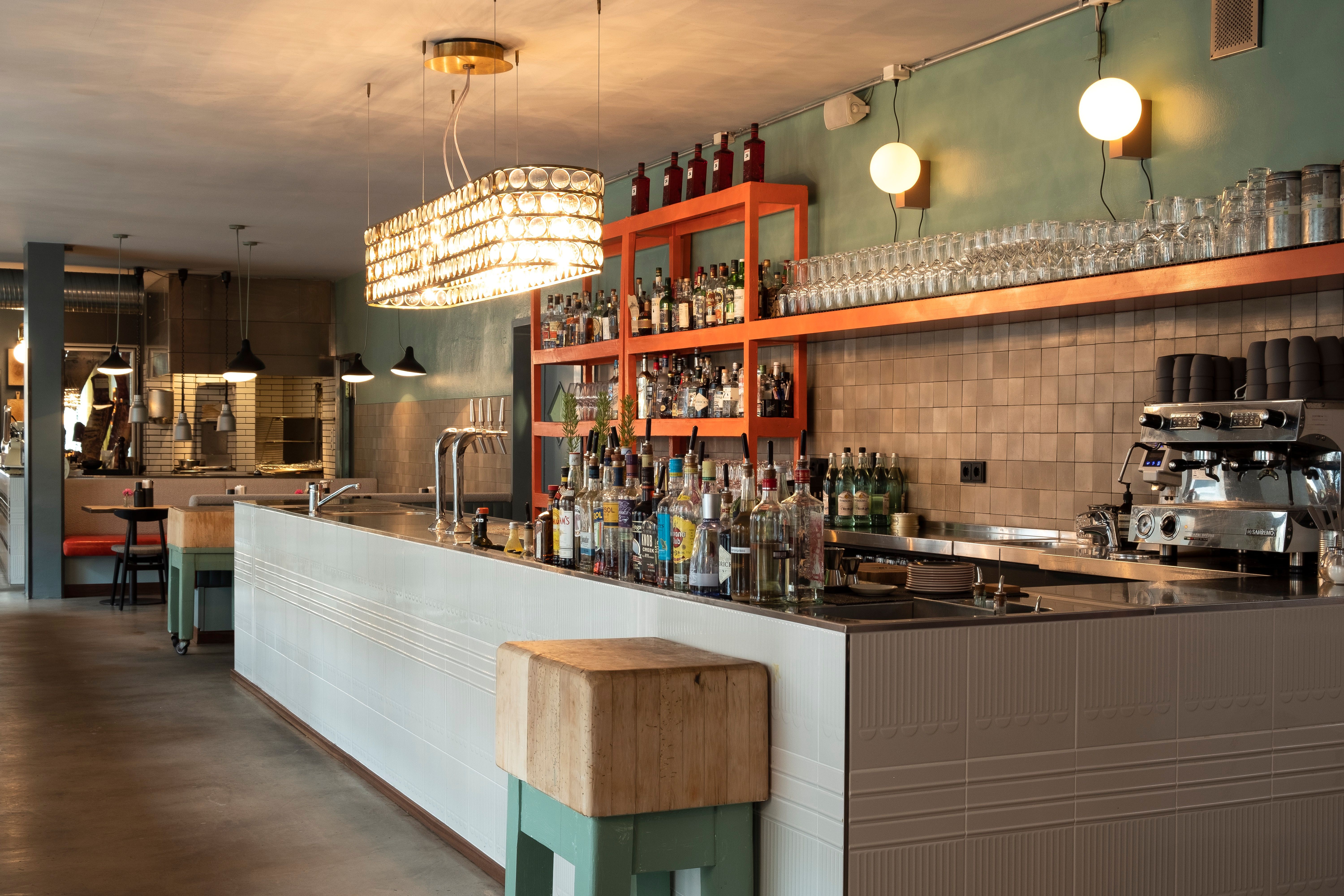 Die Kombination aus grafischen Wandmustern, Polsterbänken und Kerzenlicht unterstreicht den charakterstarken Stil der Renovierung.