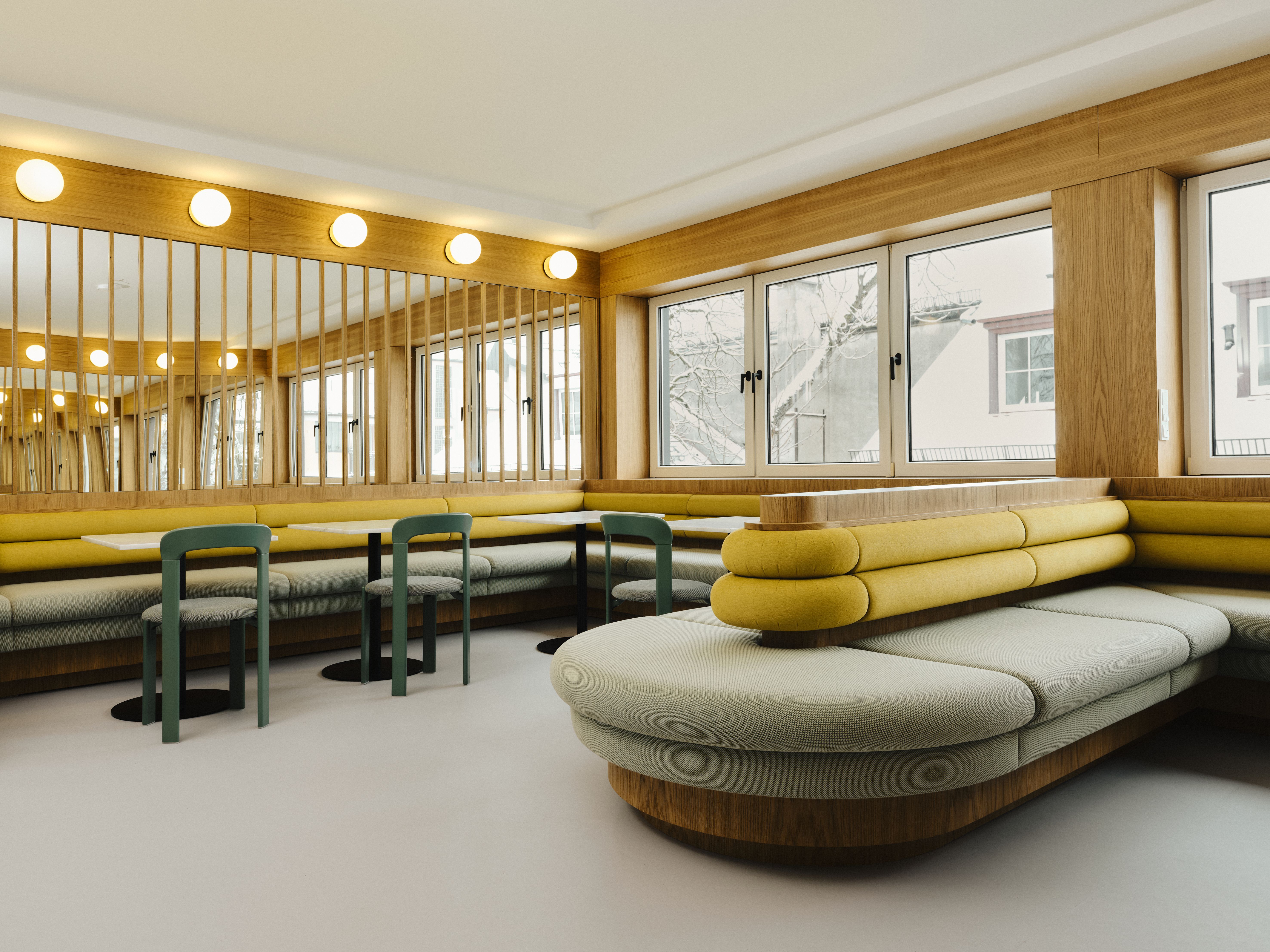 Harmonische Farbtöne, umlaufende Sitzlandschaften und klare Linien prägen den lichtdurchfluteten Gastronomiebereich, designed by Stephanie Thatenhorst.