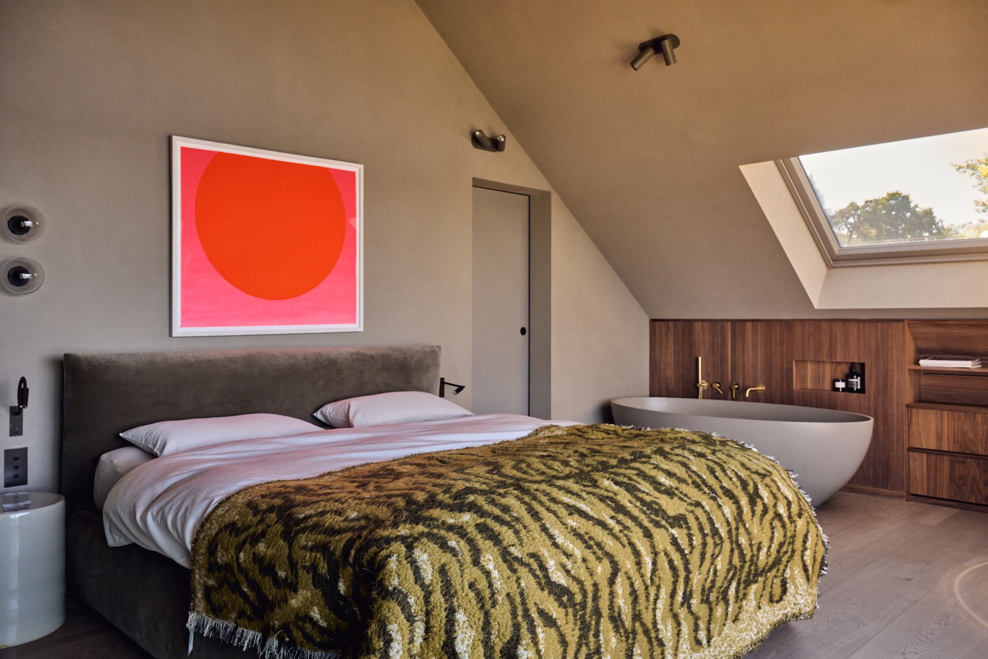 Elegantes Schlafzimmer mit freistehender Badewanne und warmen Naturmaterialien für moderne Wohlfühl-Atmosphäre.