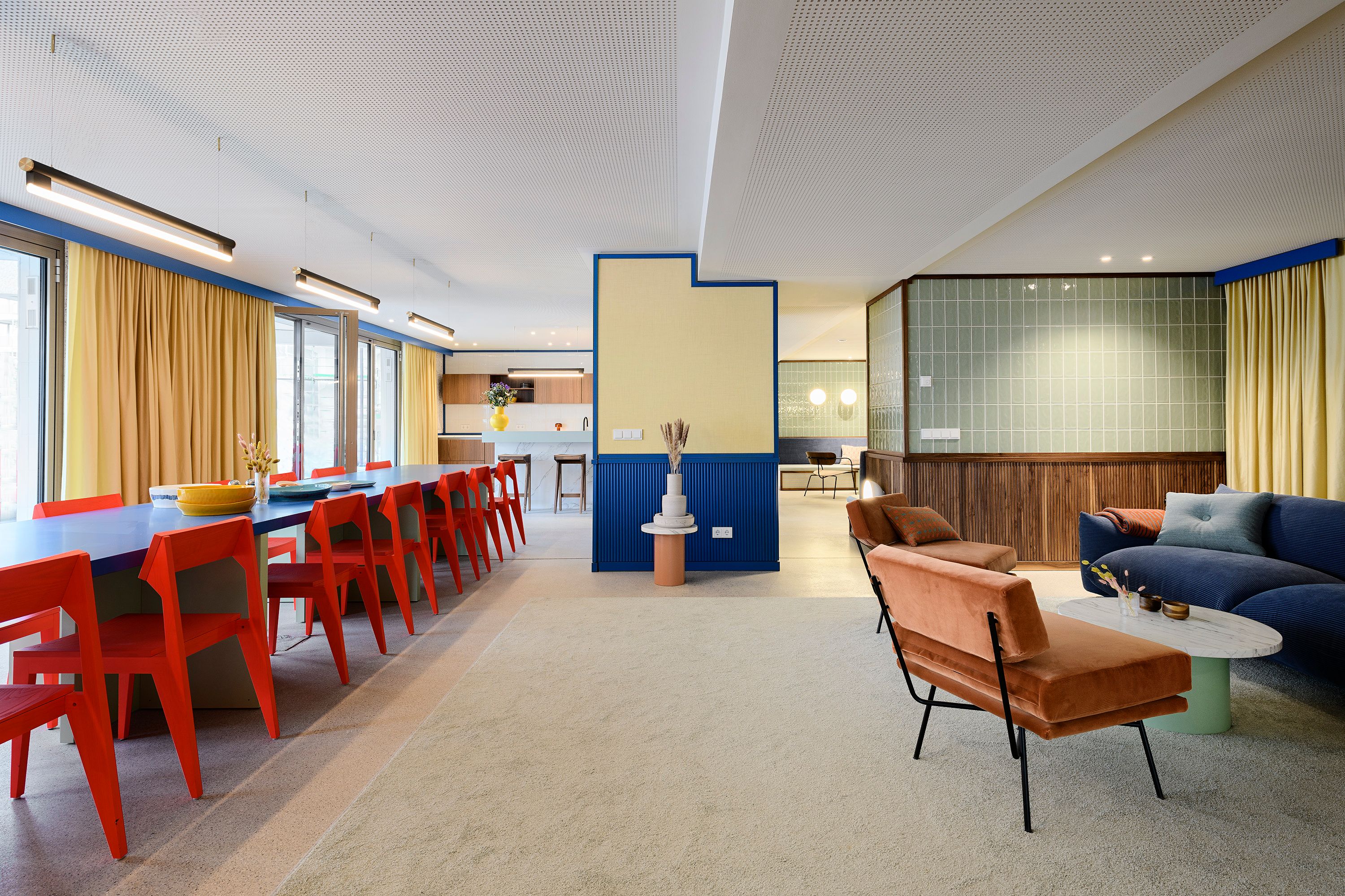 Der großzügige Raum der Kupa – Kitchen & Working Lounge, designt von Stephanie Thatenhorst, kombiniert kräftige Farben, klare Linien und vielseitige Sitzbereiche zu einem kreativen und funktionalen Arbeitsumfeld.