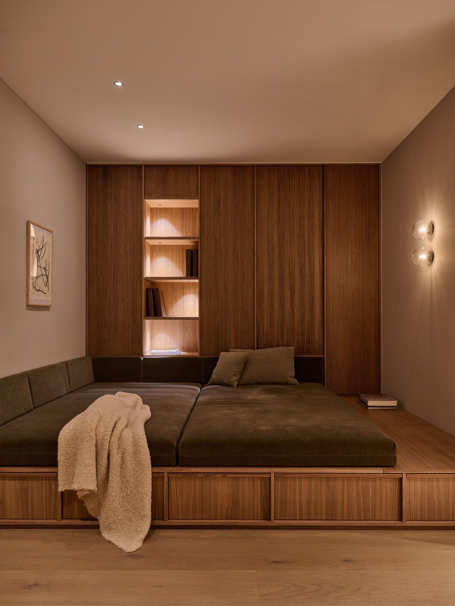 Ruhiger Rückzugsort mit maßgefertigter Holzverkleidung, integriertem Regal und großzügiger Liegefläche für ein warmes, behaglich modernes Ambiente. Ruhiger Rückzugsort mit maßgefertigter Holzverkleidung, integriertem Regal und großzügiger Liegefläche für ein warmes, behaglich modernes Ambiente.