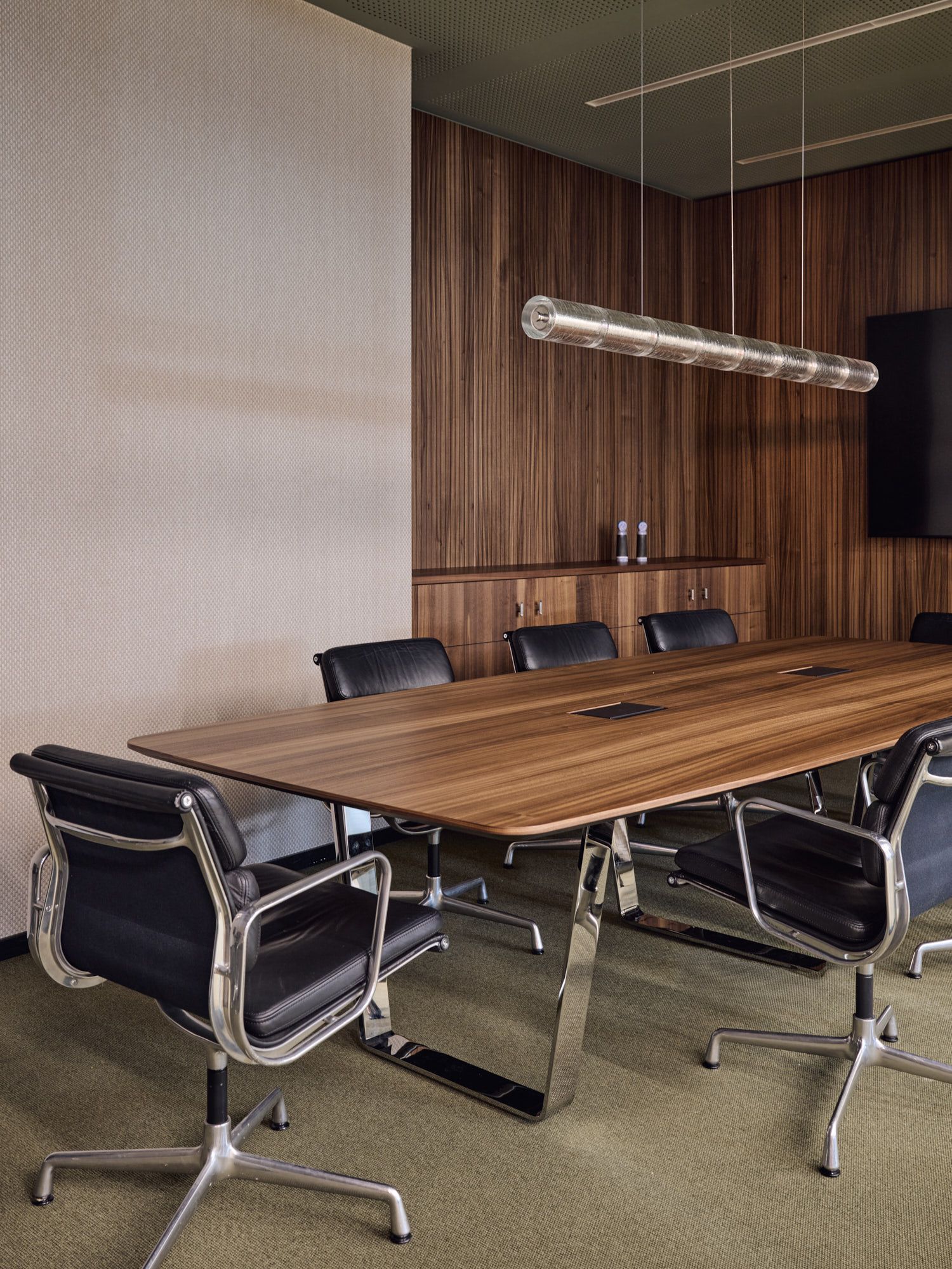 Im Büro Hass Dross Theiss gestaltet Stephanie Thatenhorst einen modernen Besprechungsraum, in dem warmes Nussbaumholz, klare Linien und hochwertige Materialien eine konzentrierte und elegante Arbeitsatmosphäre erzeugen.