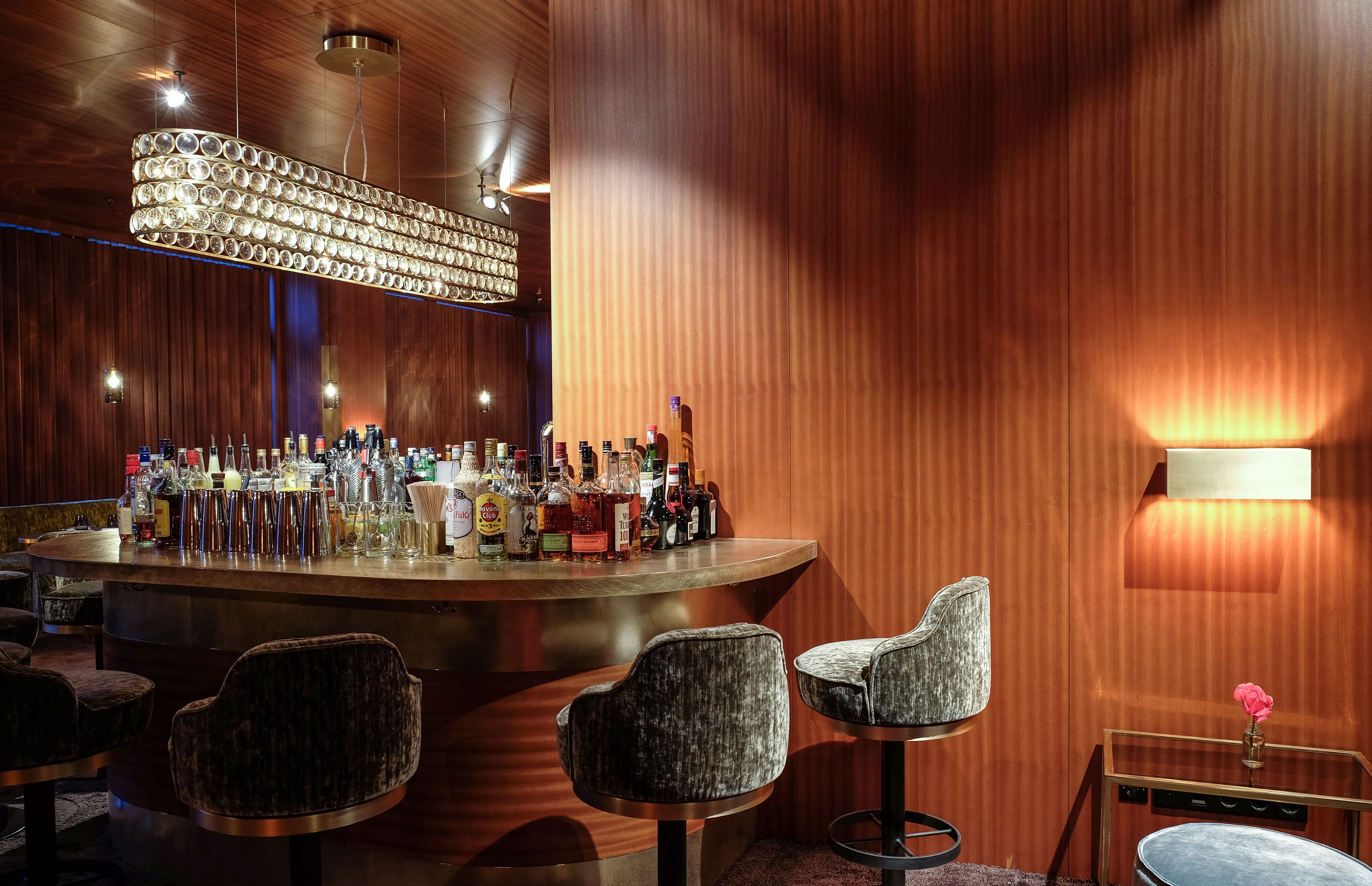 Die Kombination aus grafischer Wandstruktur, Polsterhockern und reduzierter Möblierung prägt den charakteristischen Stil der Restaurant Bar.