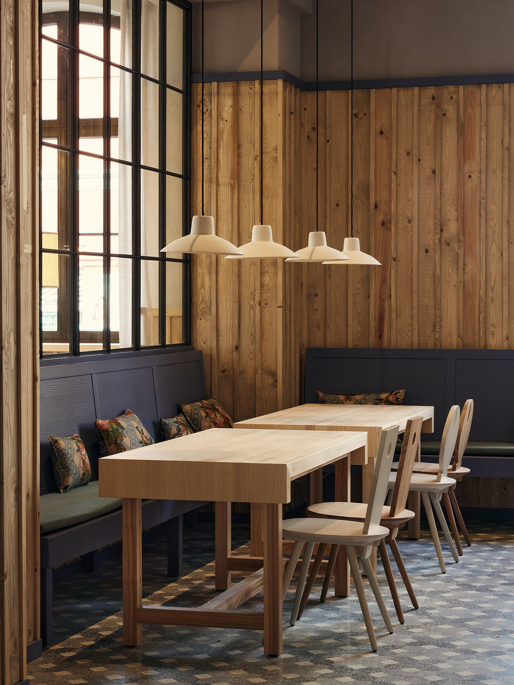 Die warmholzige Sitzlandschaft im Benediktiner Weissbräuhaus zeigt Stephanie Thatenhorsts moderne Neuinterpretation traditioneller Wirtshausarchitektur.