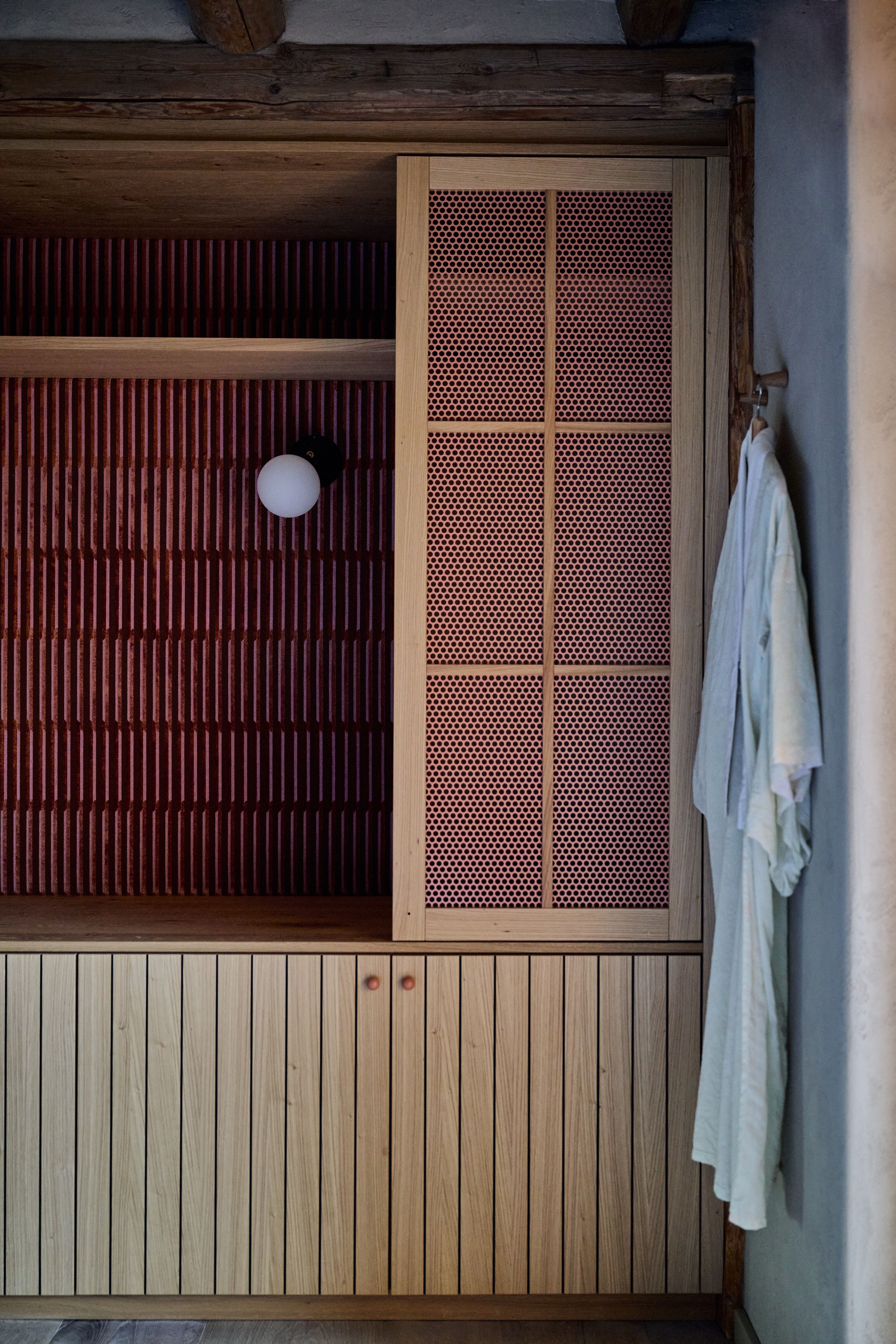 Strukturiertes Stauraum-Ensemble in Holz und Rotton mit filigraner Front und grafischer Rasterung – Interior Design von Stephanie Thatenhorst.