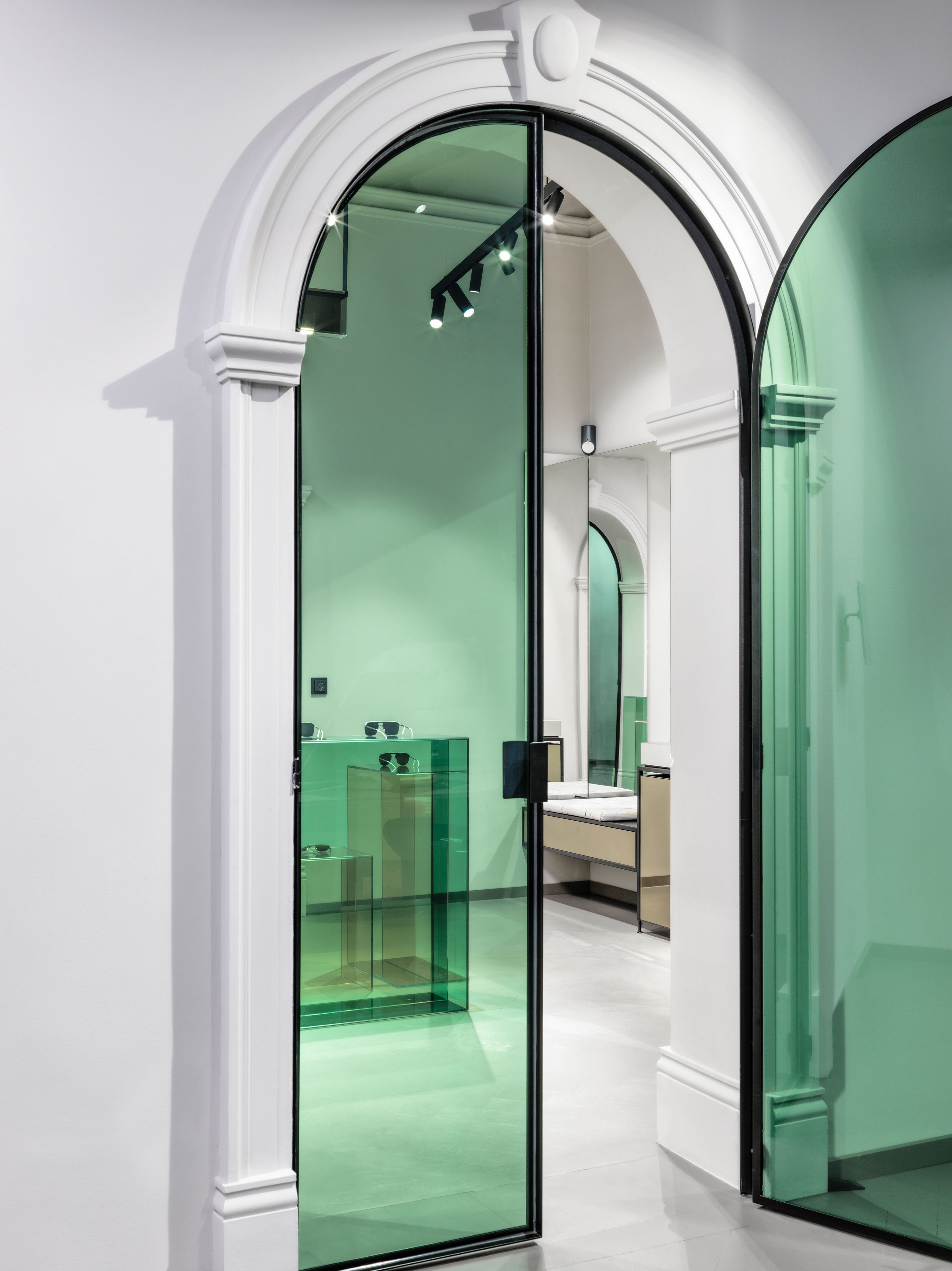 Die markante grüne Glastür im Mykita Shop München, gestaltet von Stephanie Thatenhorst, verbindet moderne Ästhetik mit architektonischer Eleganz.