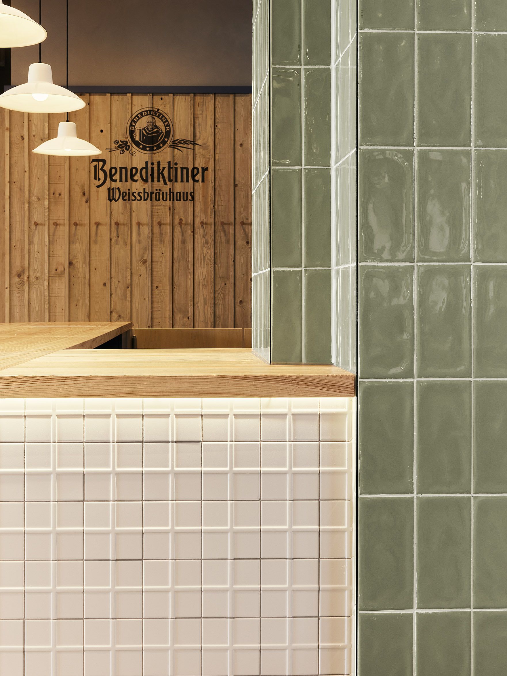Die Kombination aus glasierten Grünfliesen und strukturierter Thekenfront verleiht dem Benediktiner Weissbräuhaus einen zeitlos-handwerklichen Charakter nach dem Design von Stephanie Thatenhorst.