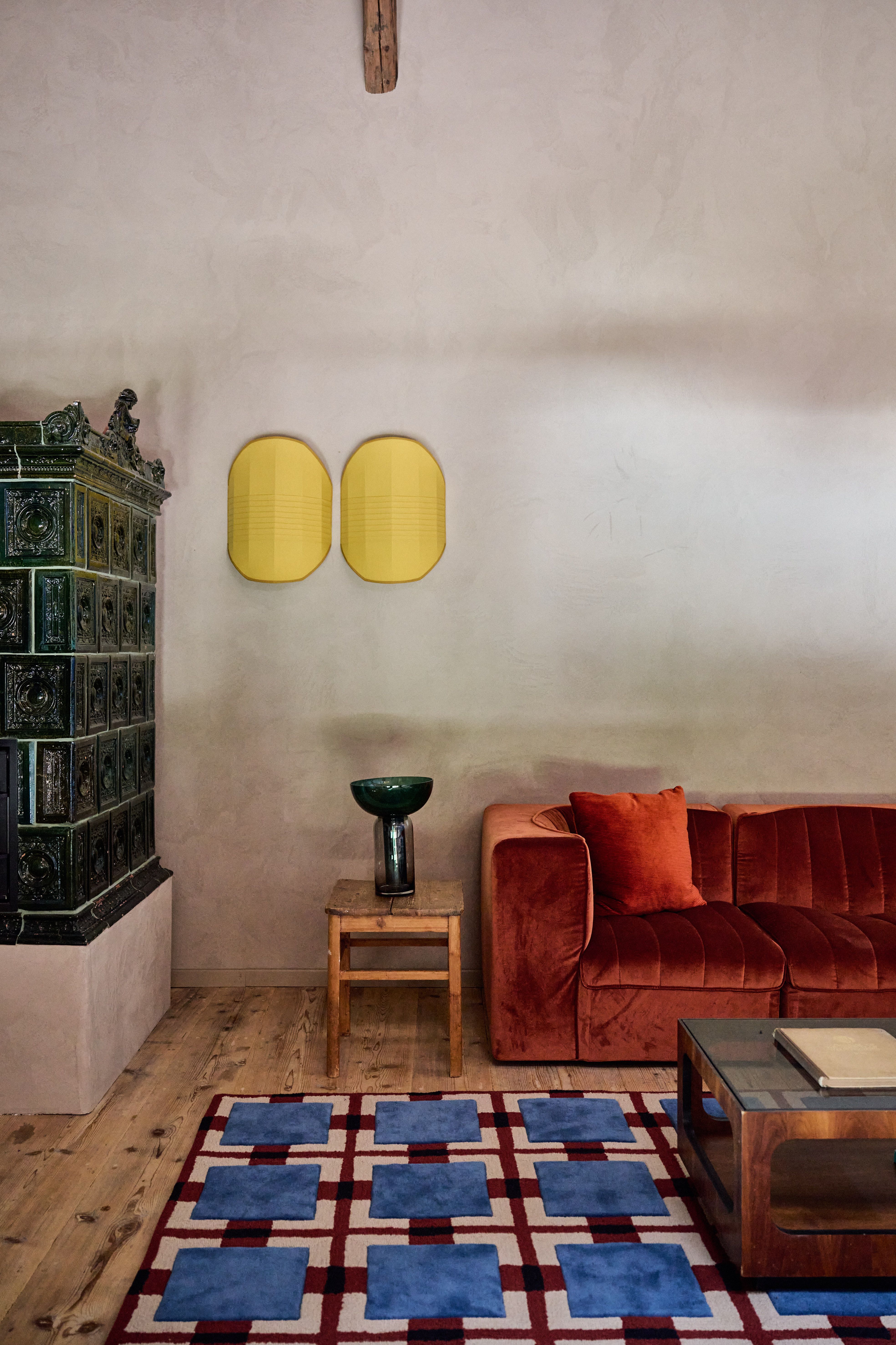 Moderne gelbe Wandplastik und Kachelofen im Farmhouse Retreat, designed by Stephanie Thatenhorst