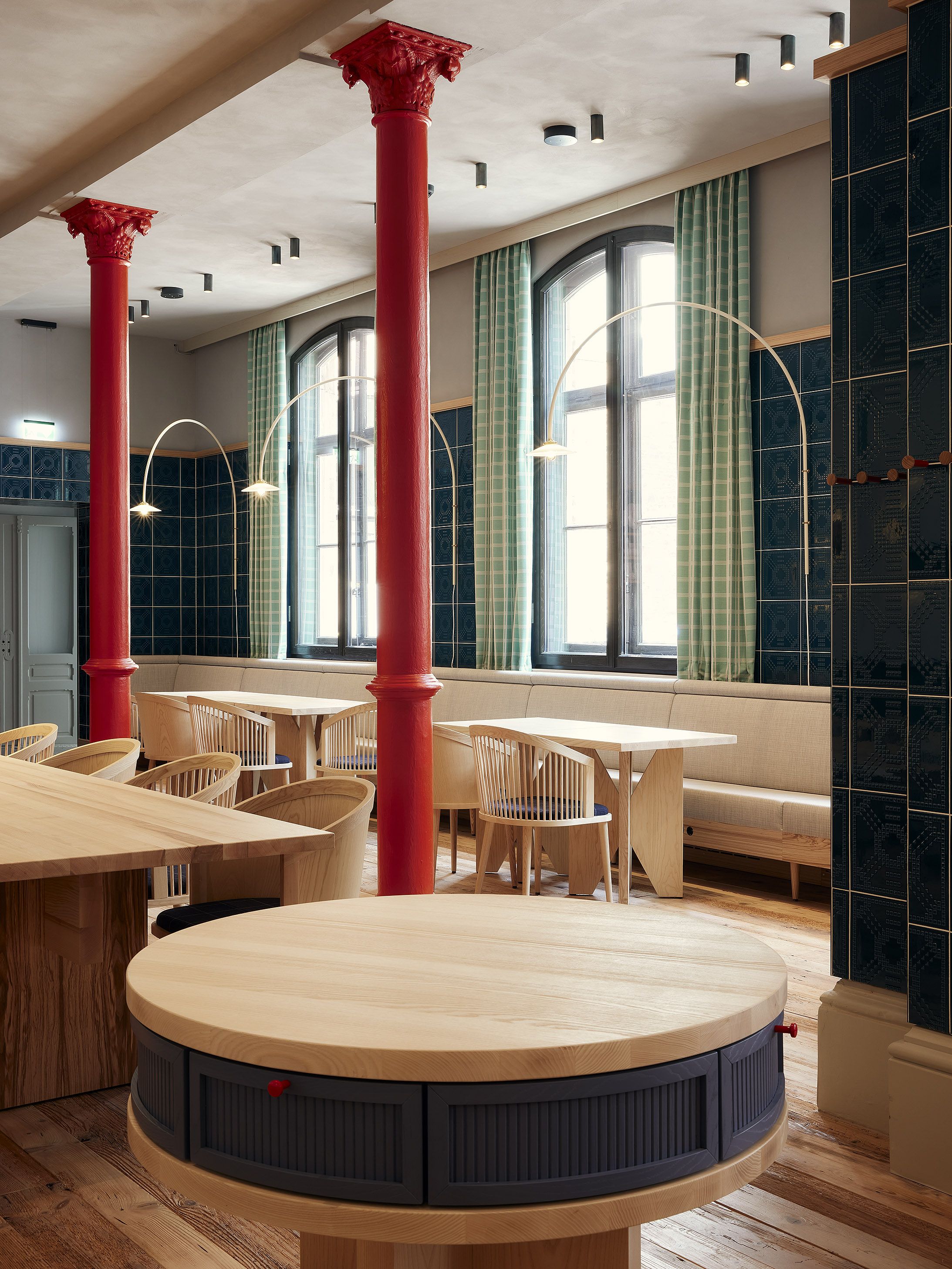 Runde Gemeinschaftstische mit integrierten Stauraumlösungen sind funktionale Designelemente des Benediktiner Weissbräuhauses und fördern kommunikatives Beisammensein.