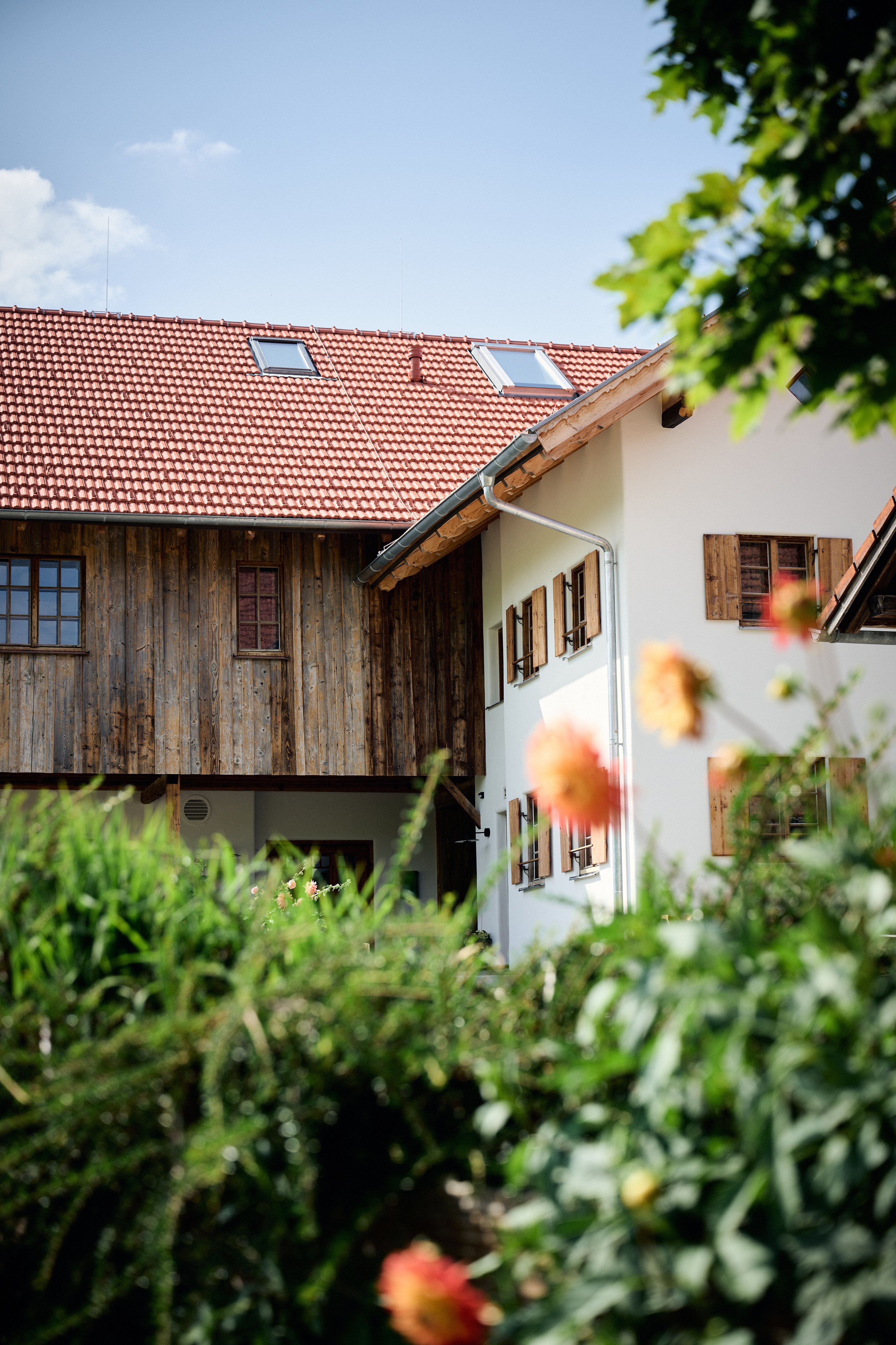 Designed by Stephanie Thatenhorst, vereint dieses detailreich renovierte Farmhaus traditionelle Holzfassaden, historische Fensterläden und klare Linienführung zu einer in der Landschaft ruhenden Architekturkomposition.