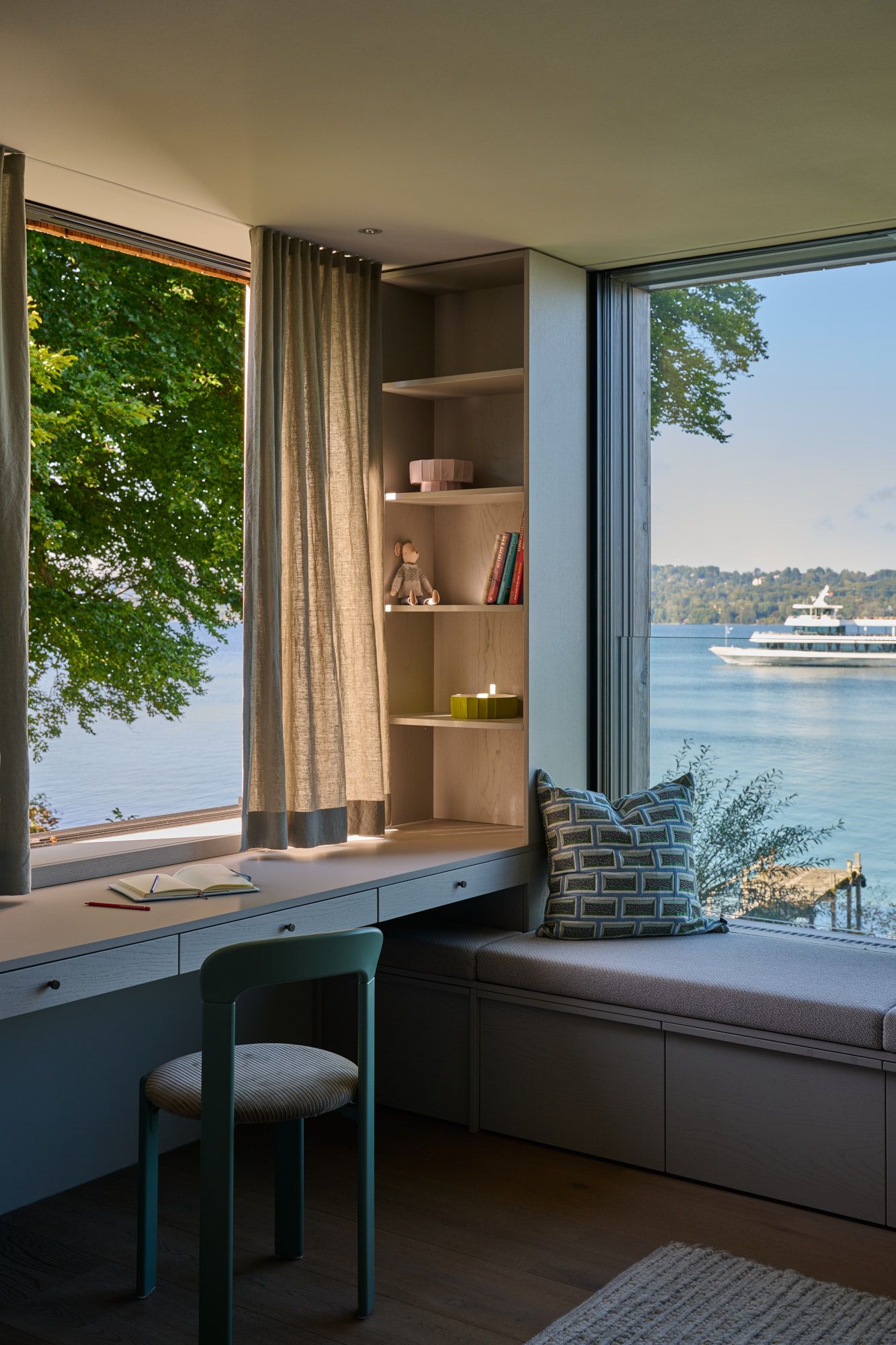 Ein lichtdurchfluteter Rückzugsort, in dem maßgeschneiderte Einrichtung, sanfte Texturen und der freie Blick auf den See zu einer ruhigen, inspirierenden Atmosphäre verschmelzen.