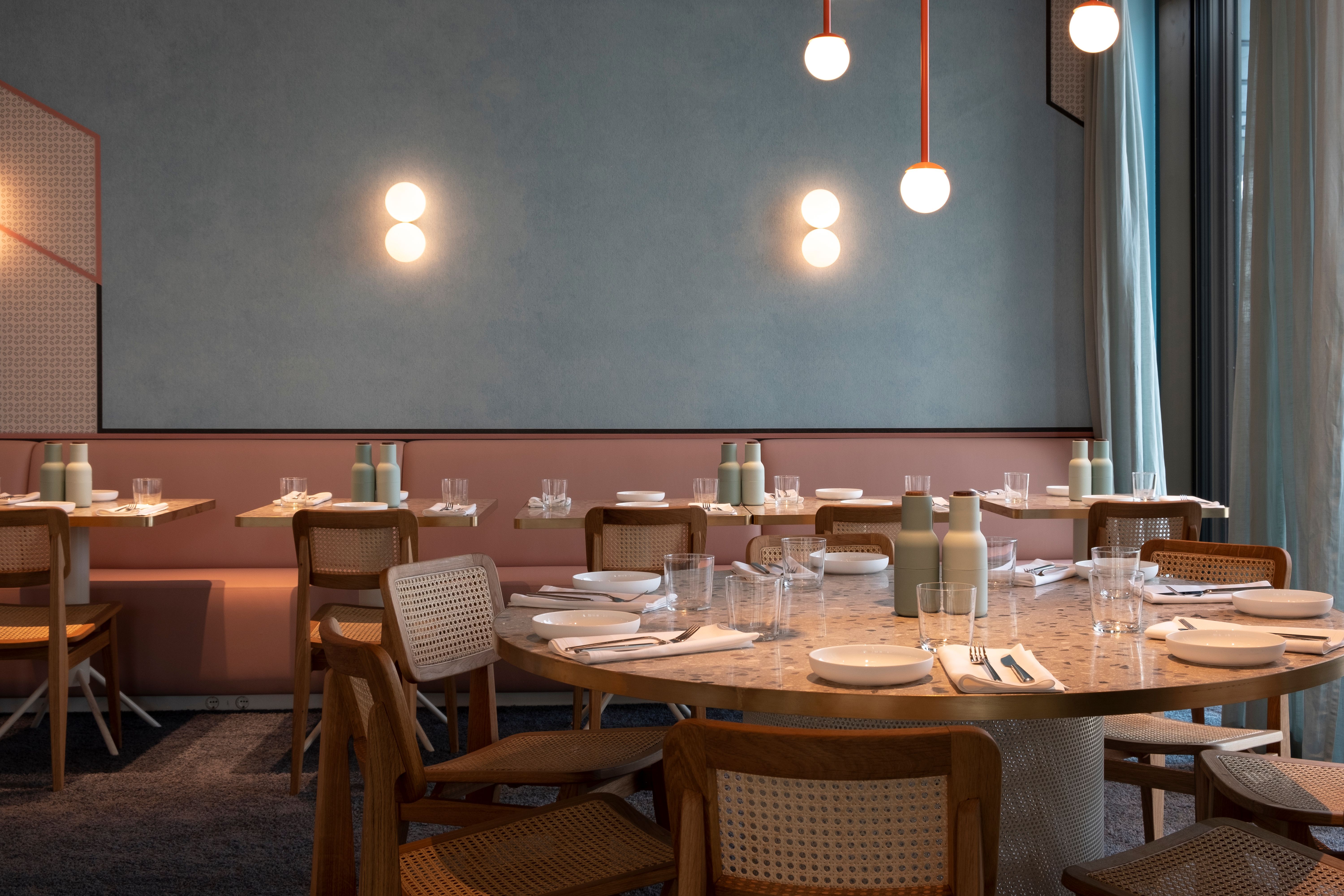 Im gedeckten Bereich des Lilli P verbindet Stephanie Thatenhorst sanfte Pastellfarben, warme Holzmöbel und dezente Beleuchtung zu einer einladenden, modernen Restaurantatmosphäre.