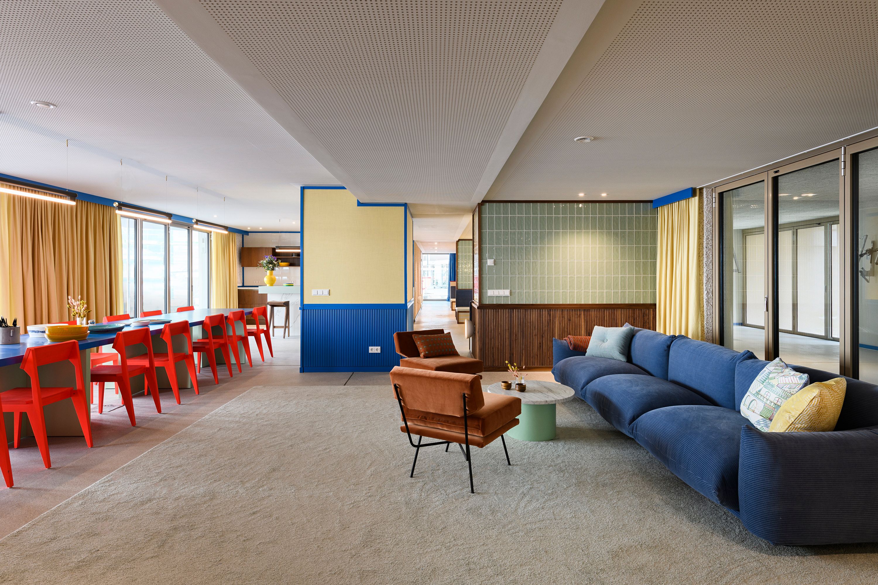 Dieses großzügige Lounge-Setting mit blauem Sofa und farbstarken Akzenten wurde von Stephanie Thatenhorst designt und prägt die einladende Atmosphäre der Kupa – Kitchen & Working Lounge.